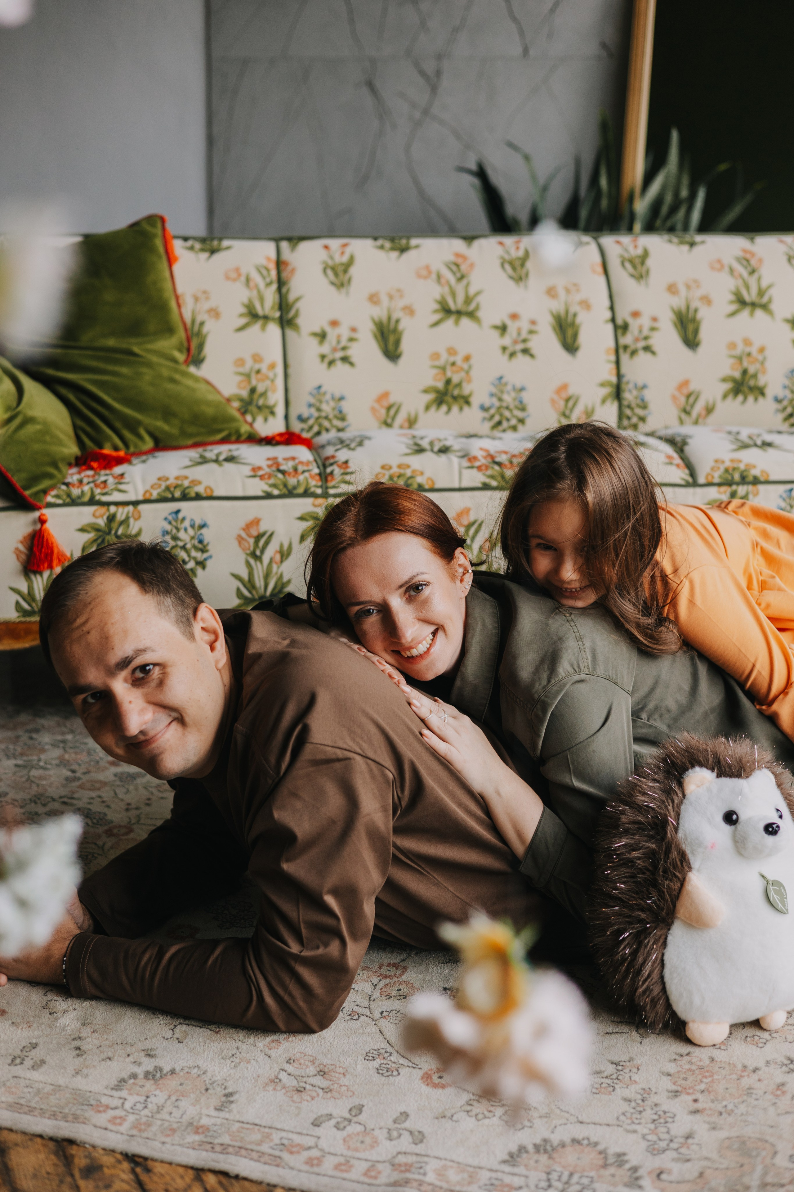 Счастливые родители и дочка в студии на семейной фотосессии