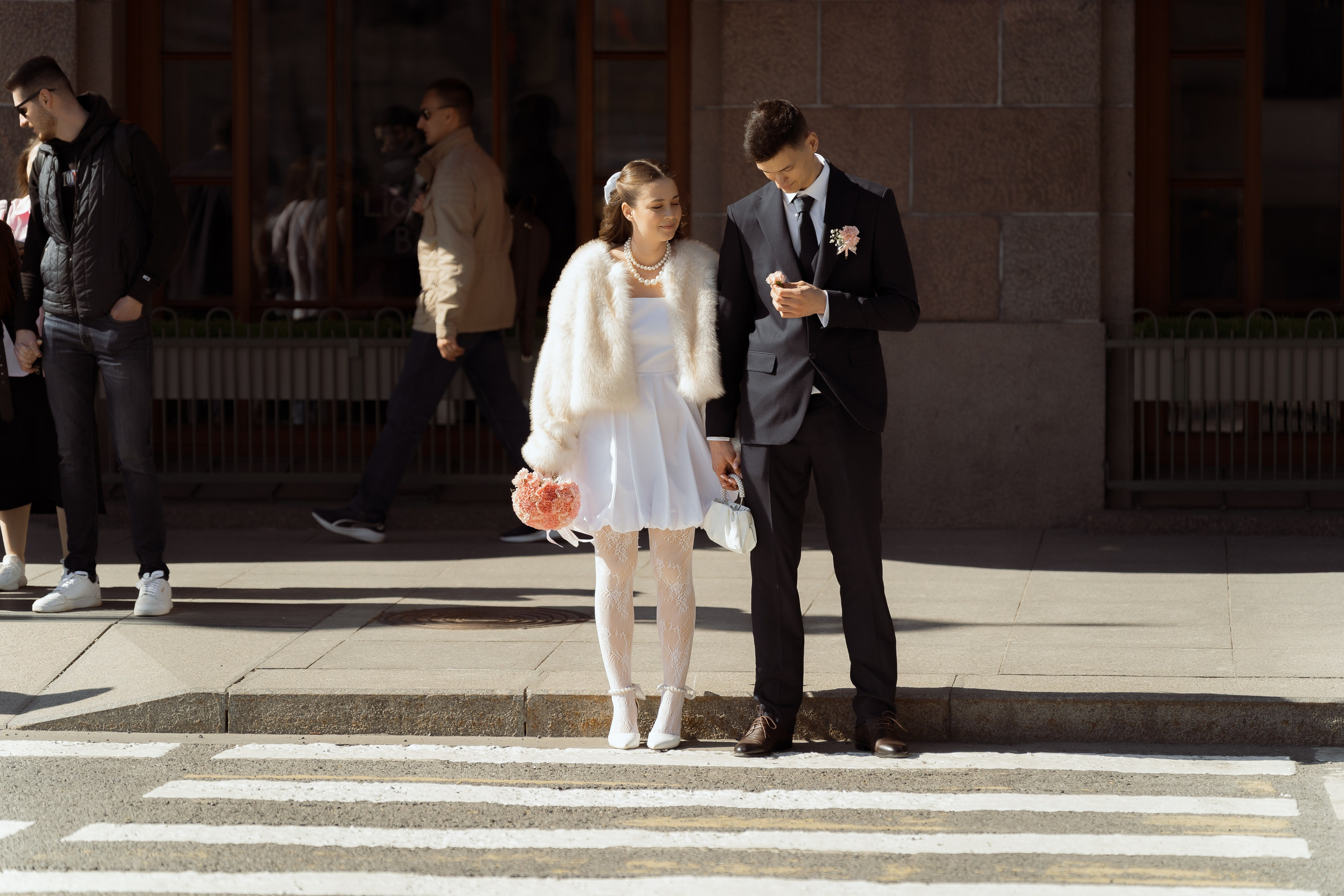 Пара стоит на пешеходном переходе, живая съёмка свадьбы в центре Петербурга