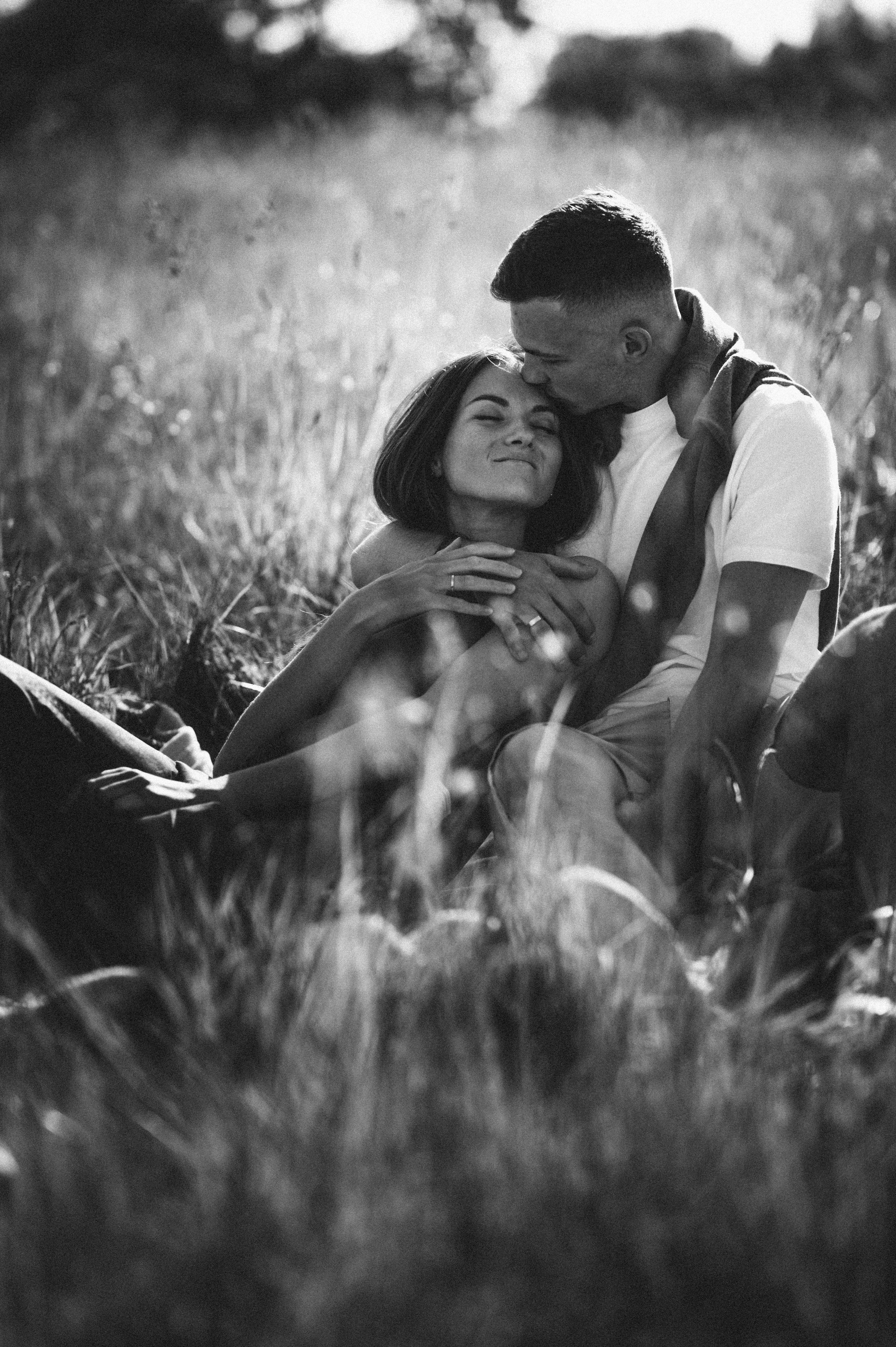 Черно-белая фотография объятий парня и девушки в летнем поле