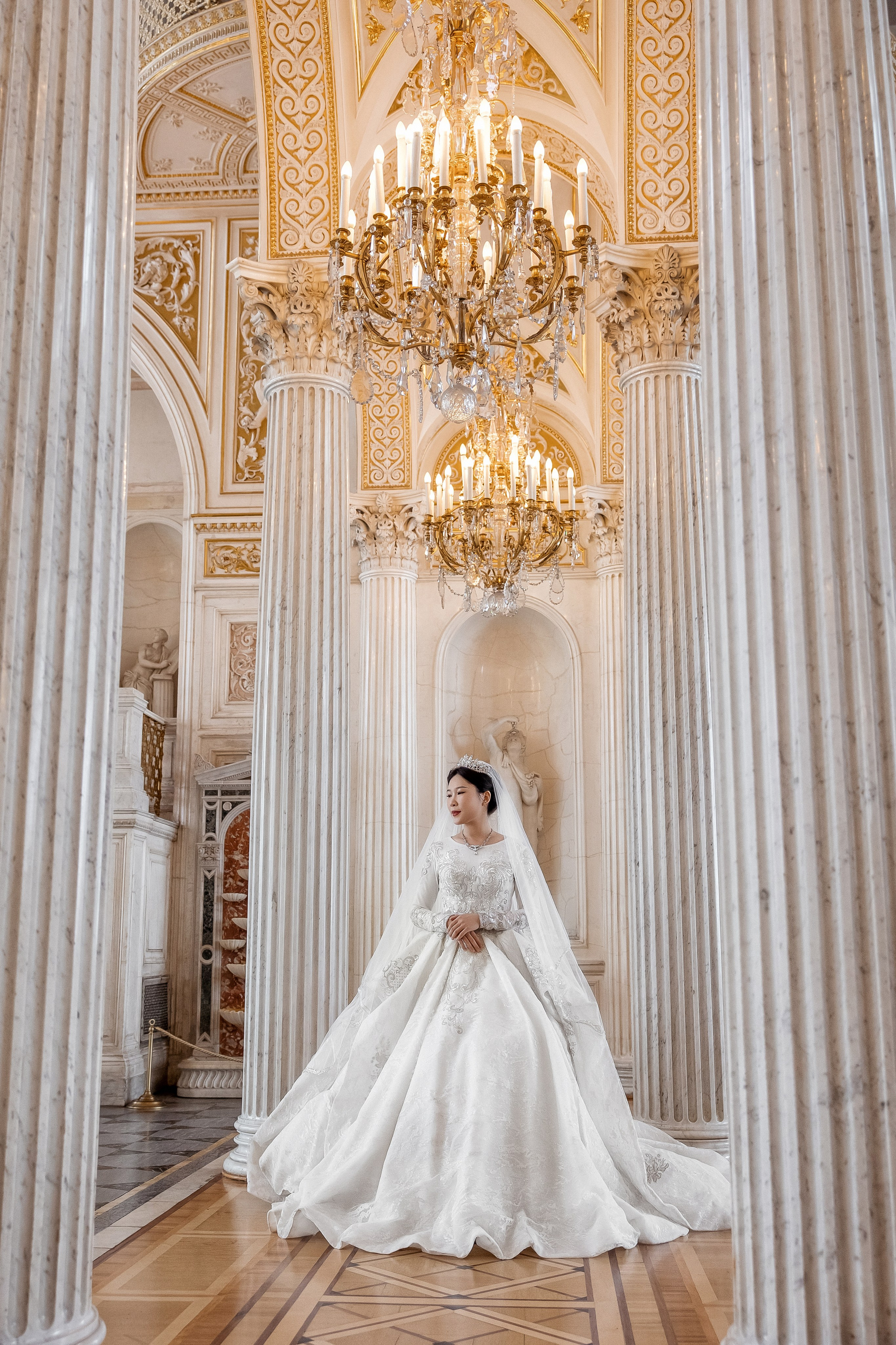 Красивый портрет невесты в дворцовом интерьере с колоннами и люстрами в Санкт-Петербурге