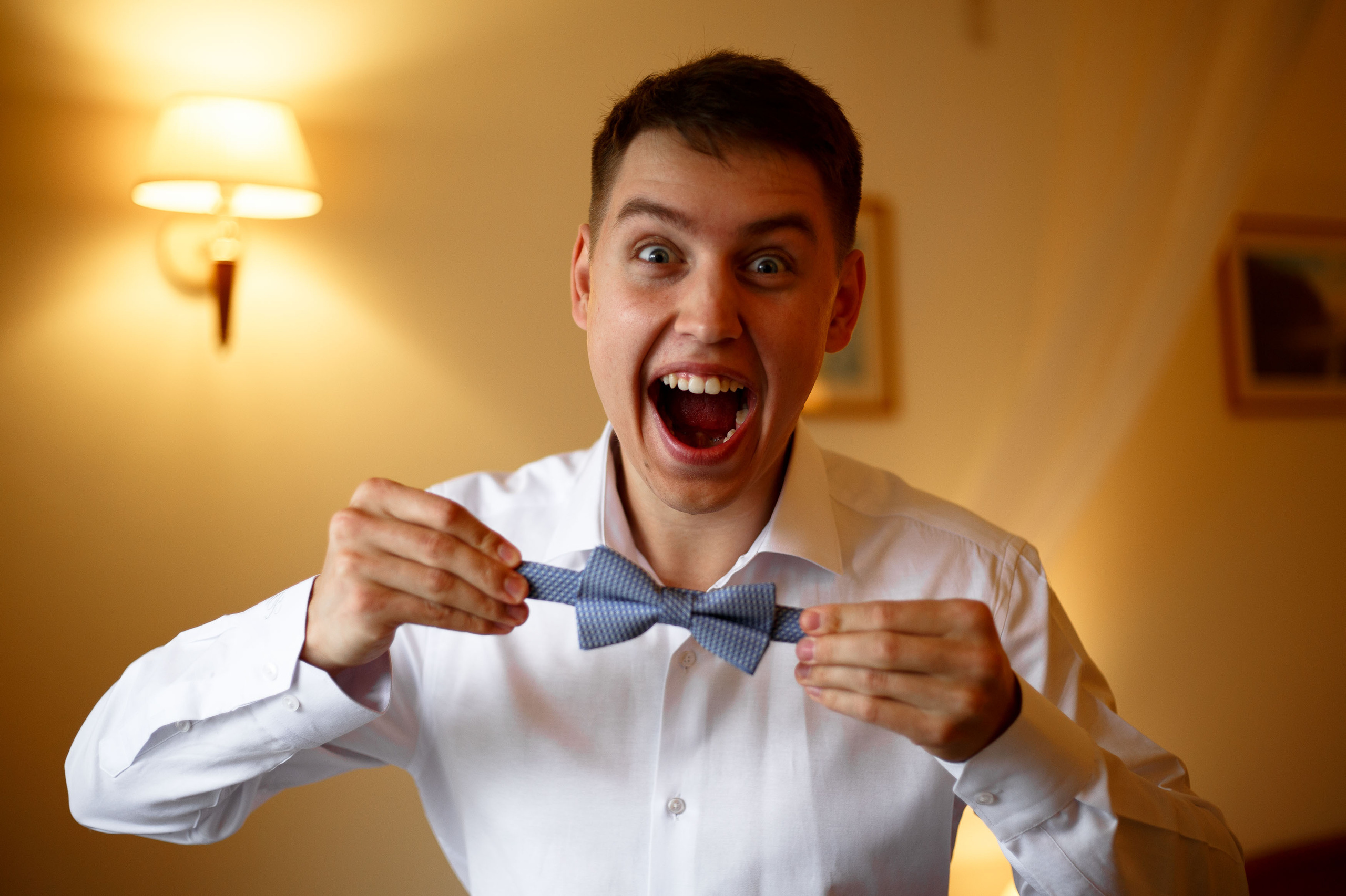 счастливый жених держит бабочку галстук