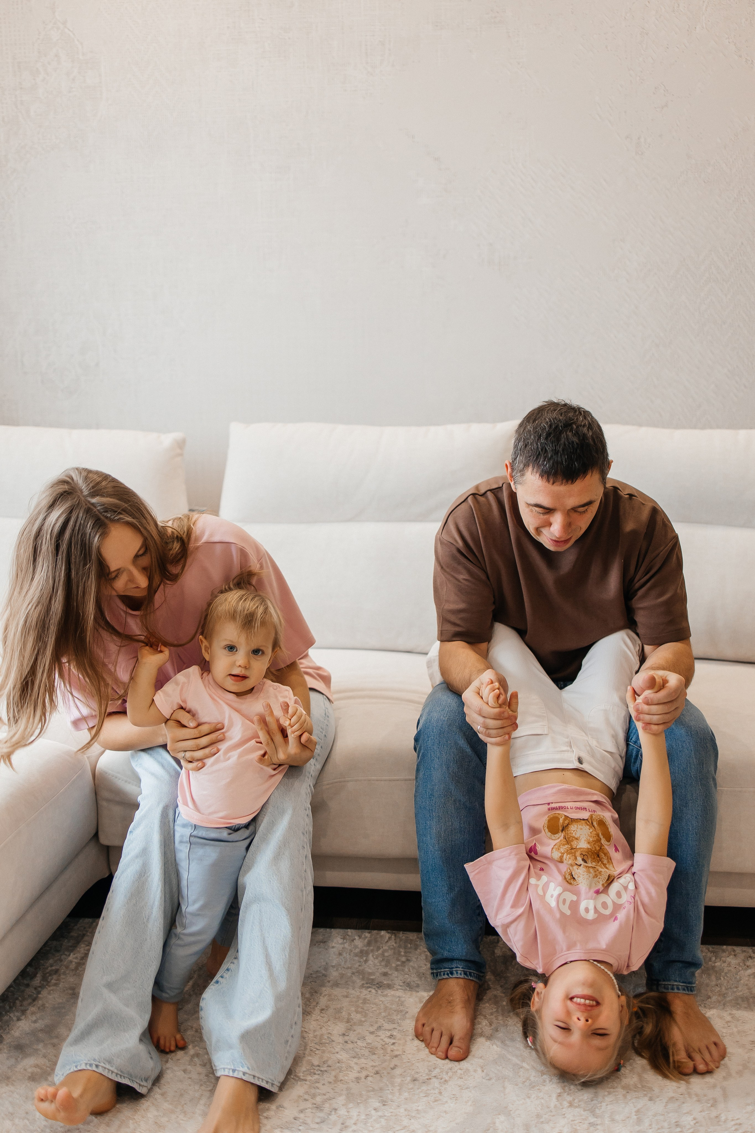 Домашняя семейная фотосессия Москва: родители и дети 2,6 лет обнимаются на диване