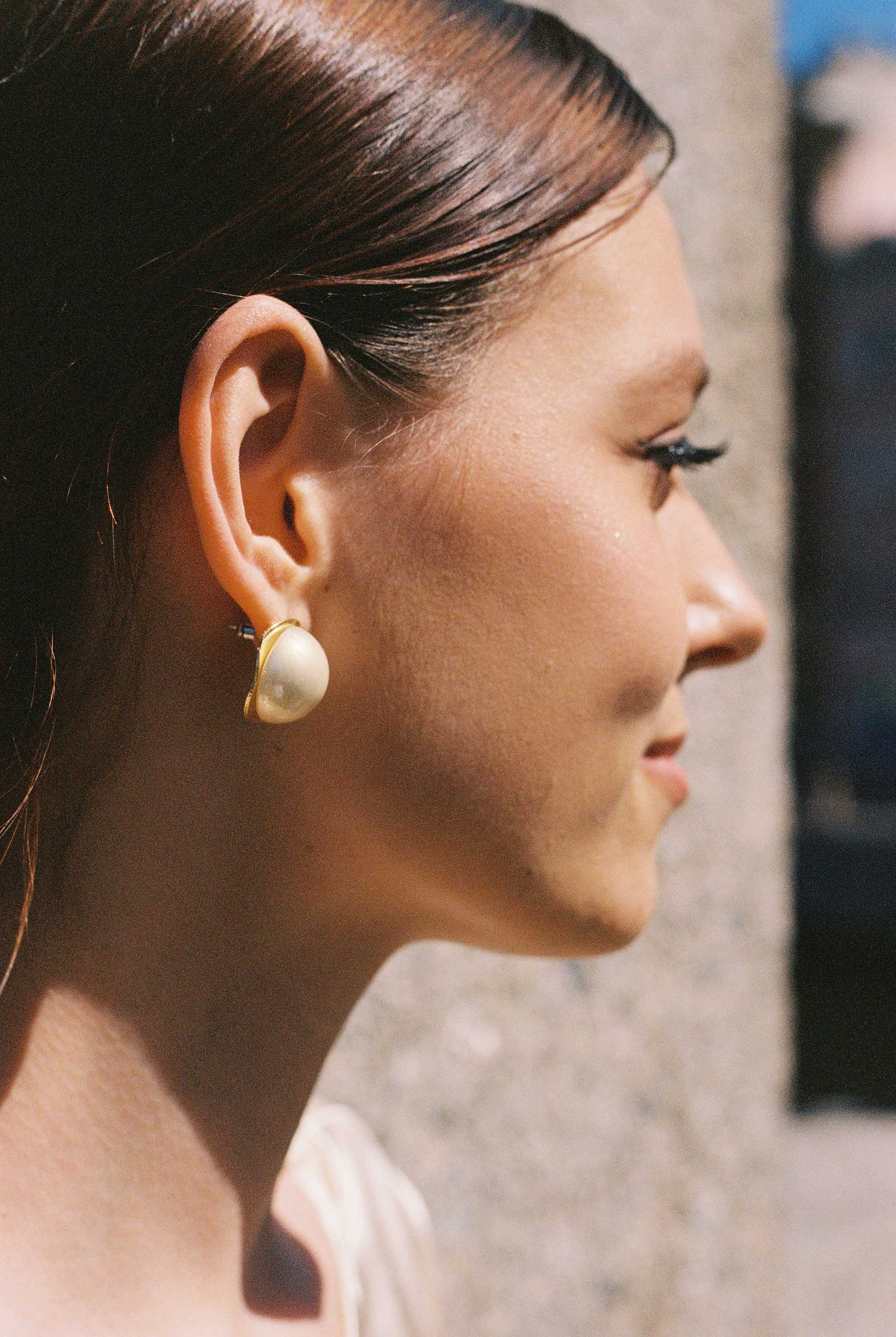 Плёночный портрет профиля невесты с жемчужной серьгой в солнечном свете