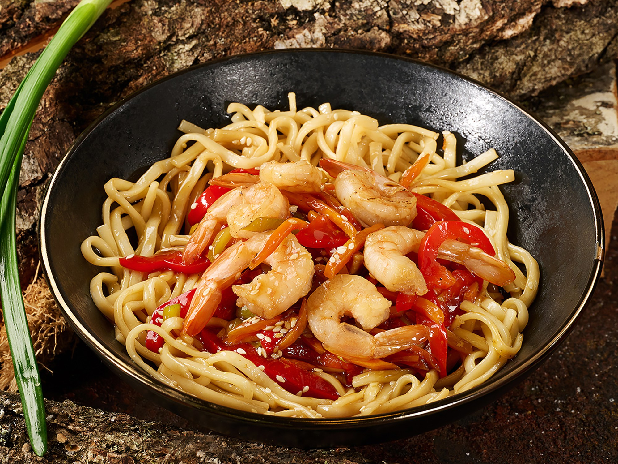 паста с креветками в черной тарелке