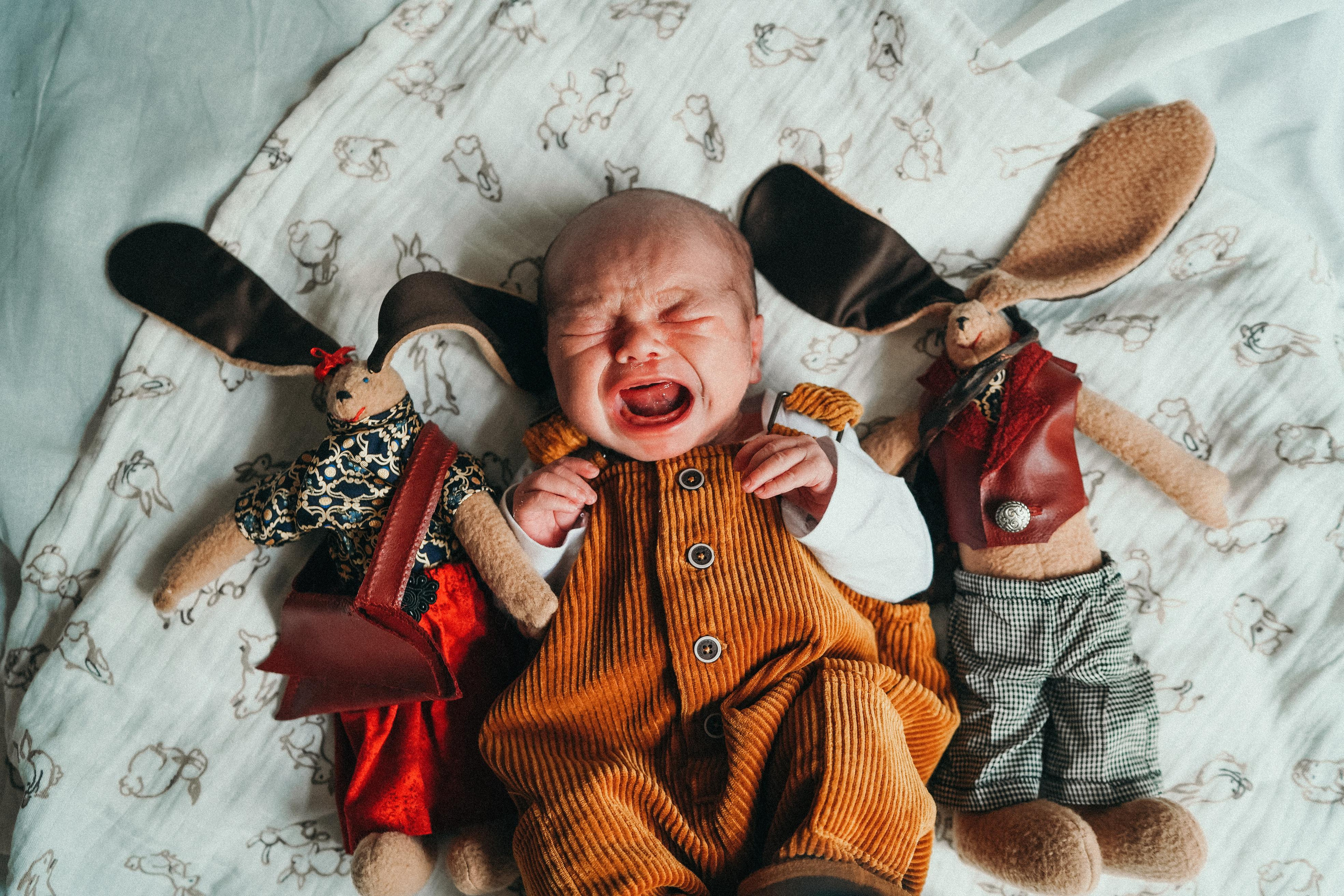 Громкий плачь новорожденного малыша с любимыми игрушками. Кадр.