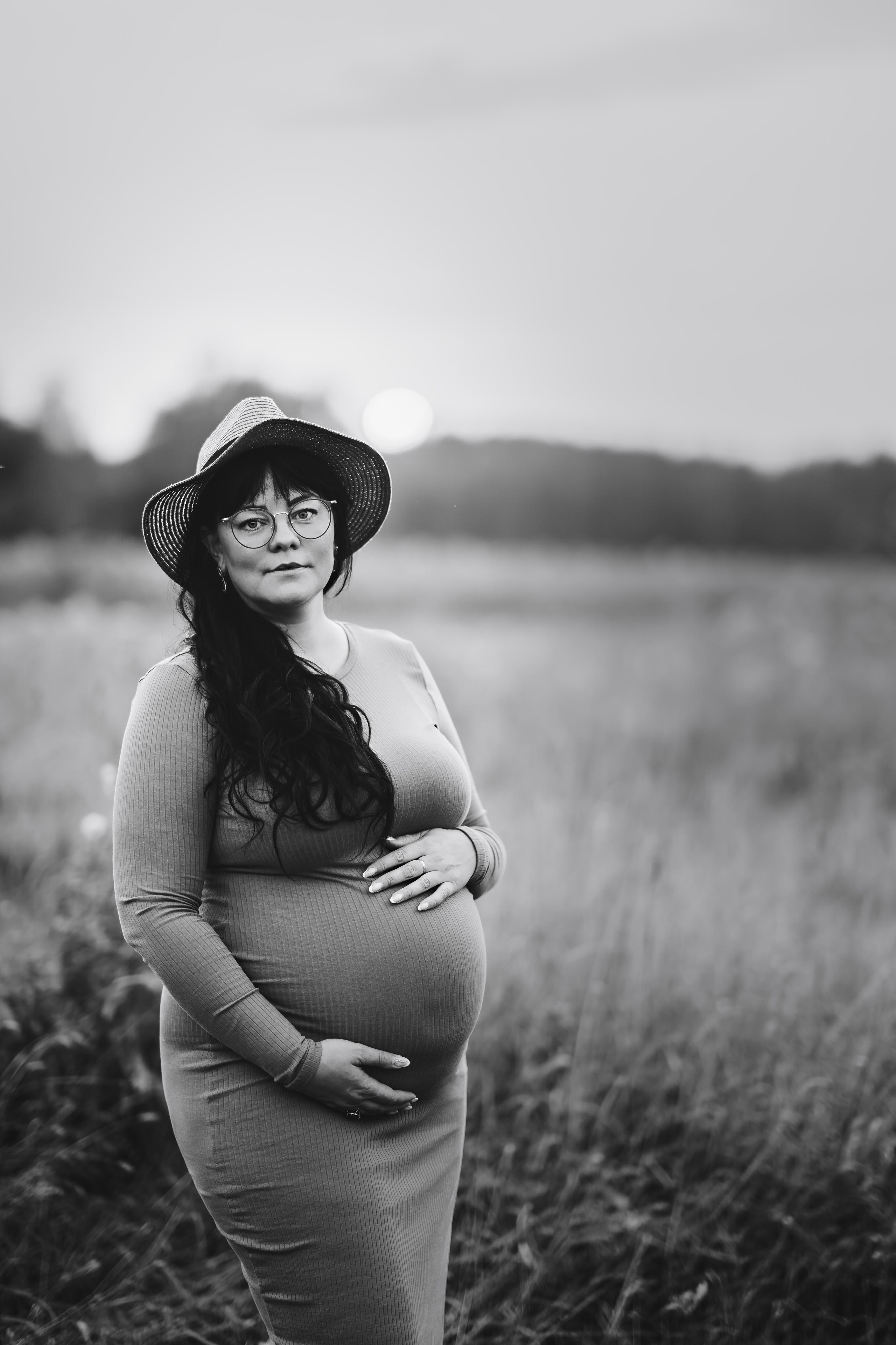 Черно-белая фотография. Беременная женщина в соломенной шляпе. Стильная фотосессия.