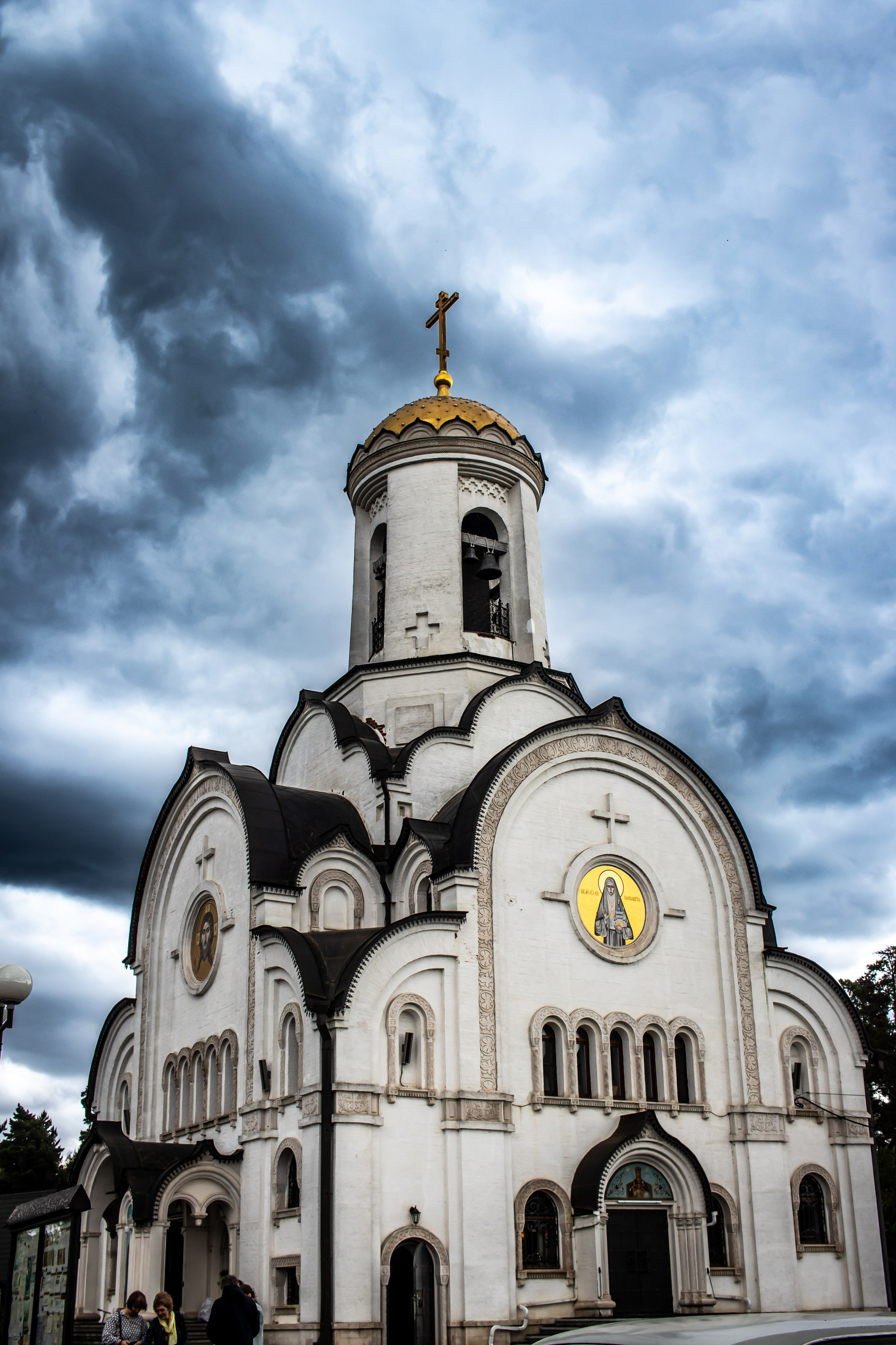 Семья участника крещения на церковной службе, все люди одеты в парадные одежды и присутствуют на богослужении