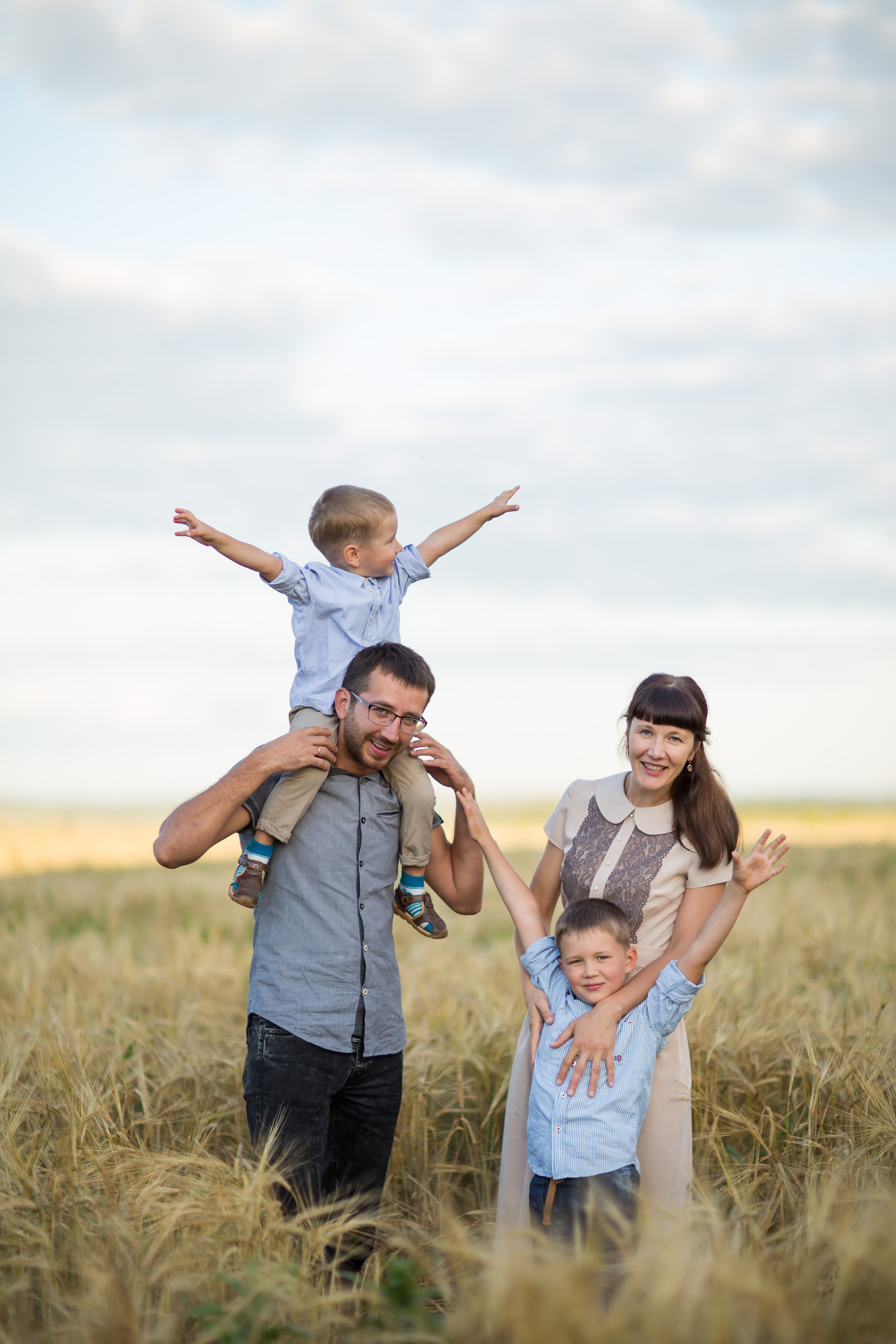 семейная фотография мамы, папы и двух сыновей в пшеничном поле