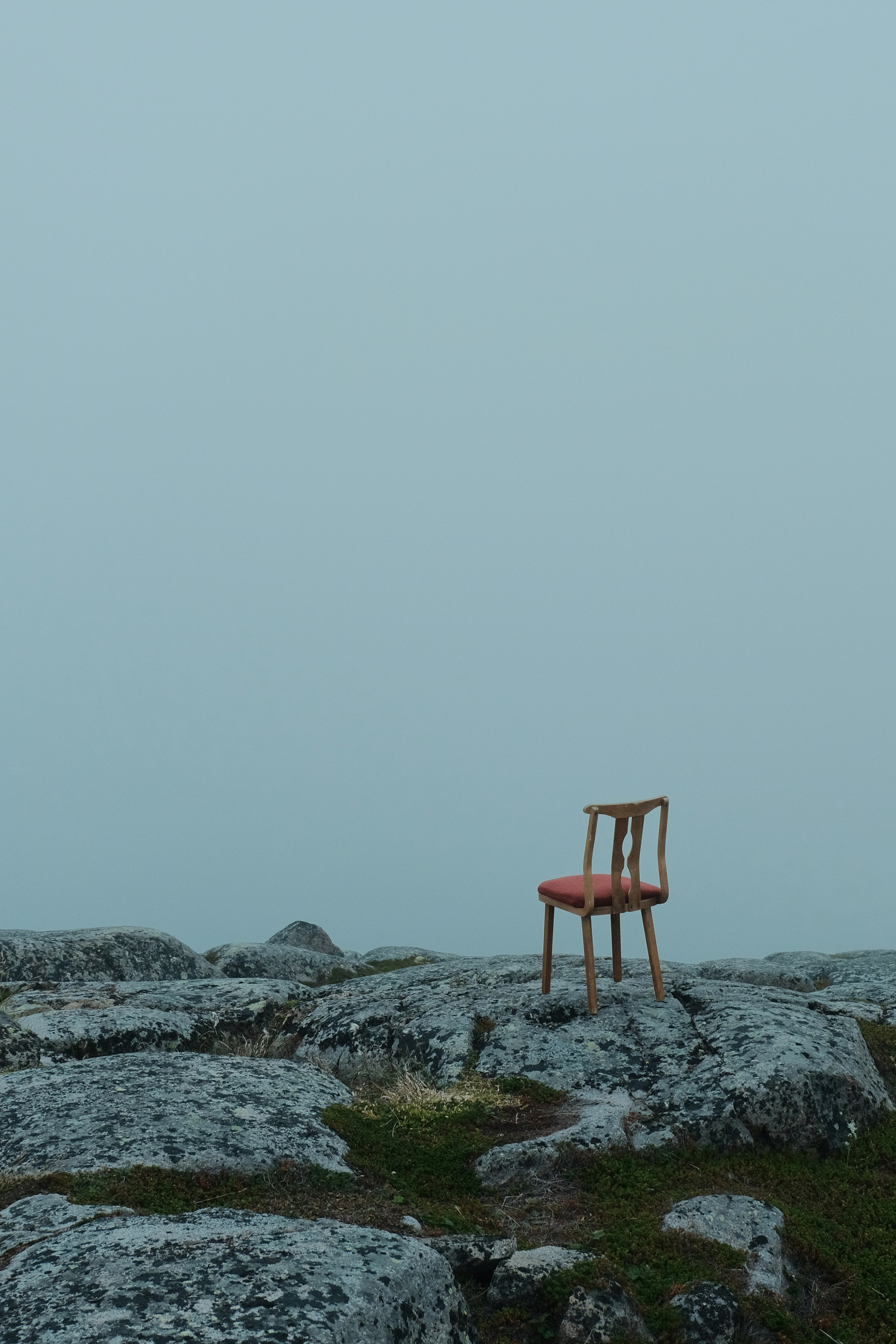 chair sitting on a rocky area with a fog