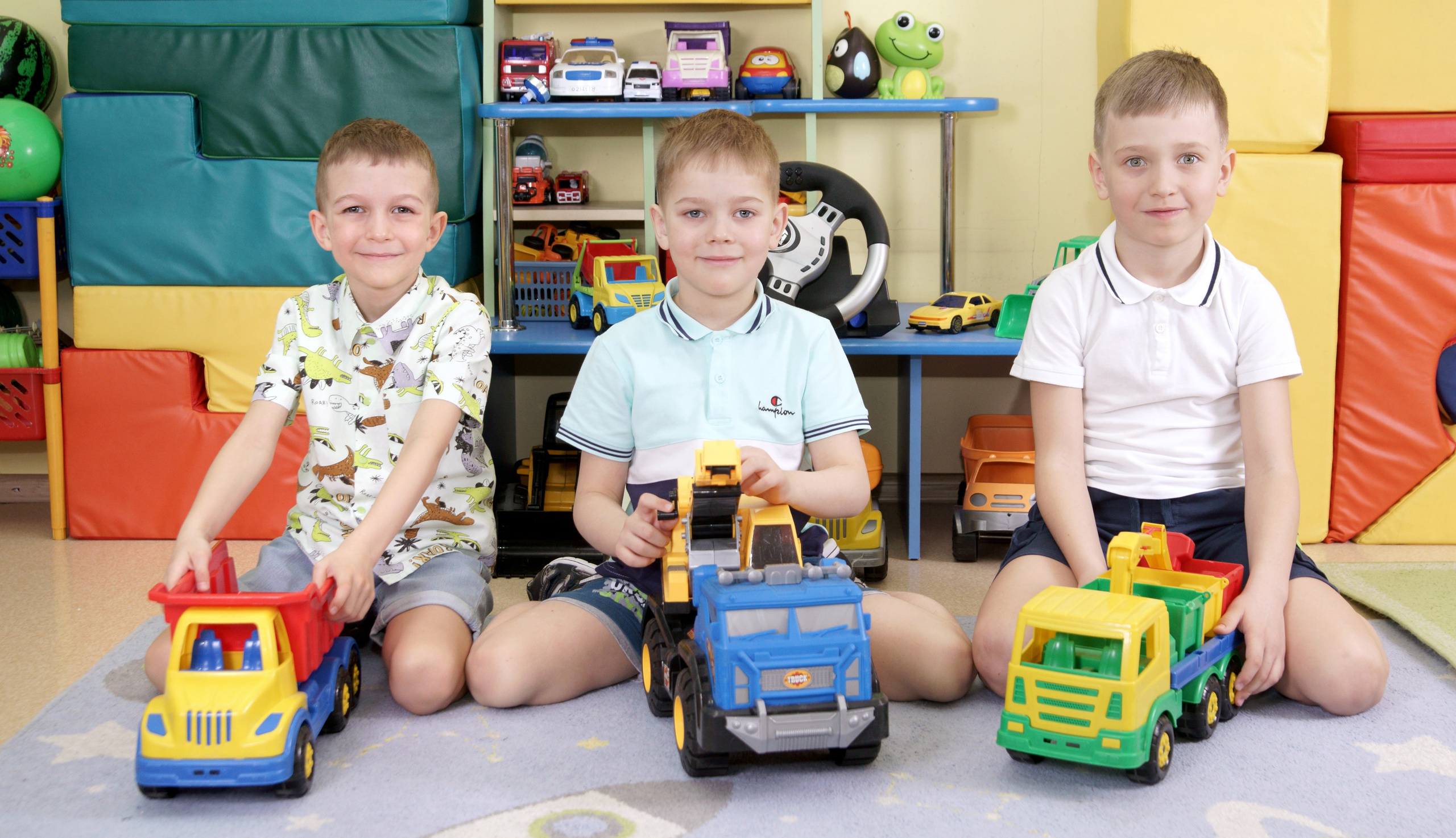 Фотосессия выпускников детского сада в группе - мальчики сидя с машинками
