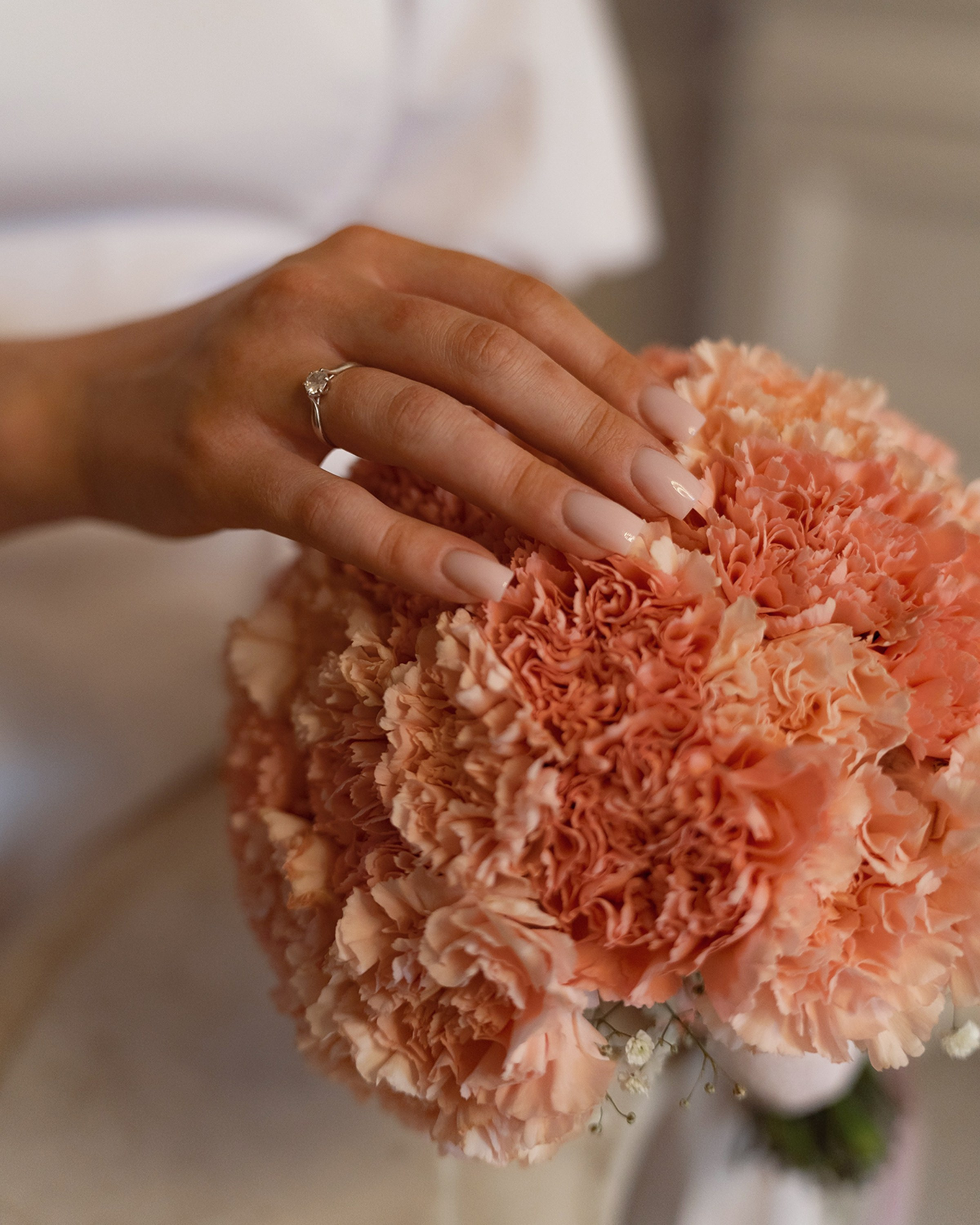 Свадебное кольцо невесты и букет из гвоздик, детали фотосессии