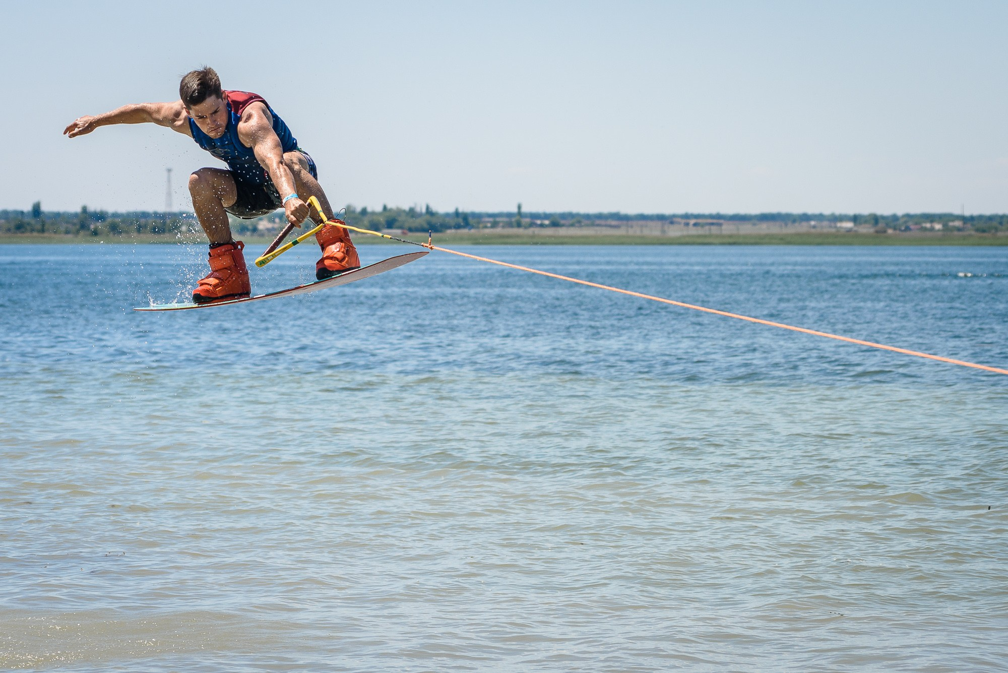 Спортсмен на скимборде в полёте над водой