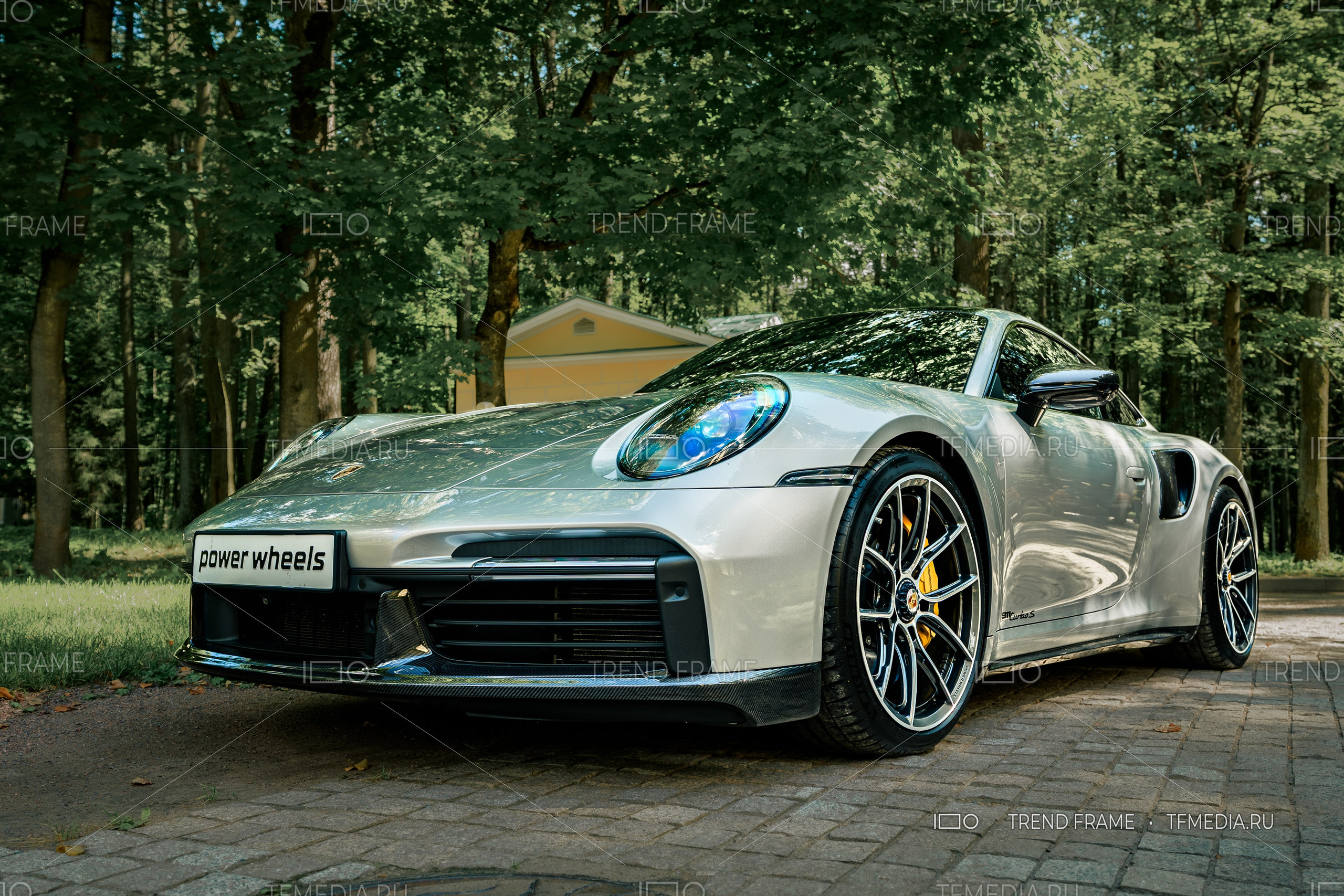 Porsche 911 Turbo S на выставке автомобилей в Москве, премиальное фото на фоне природы.