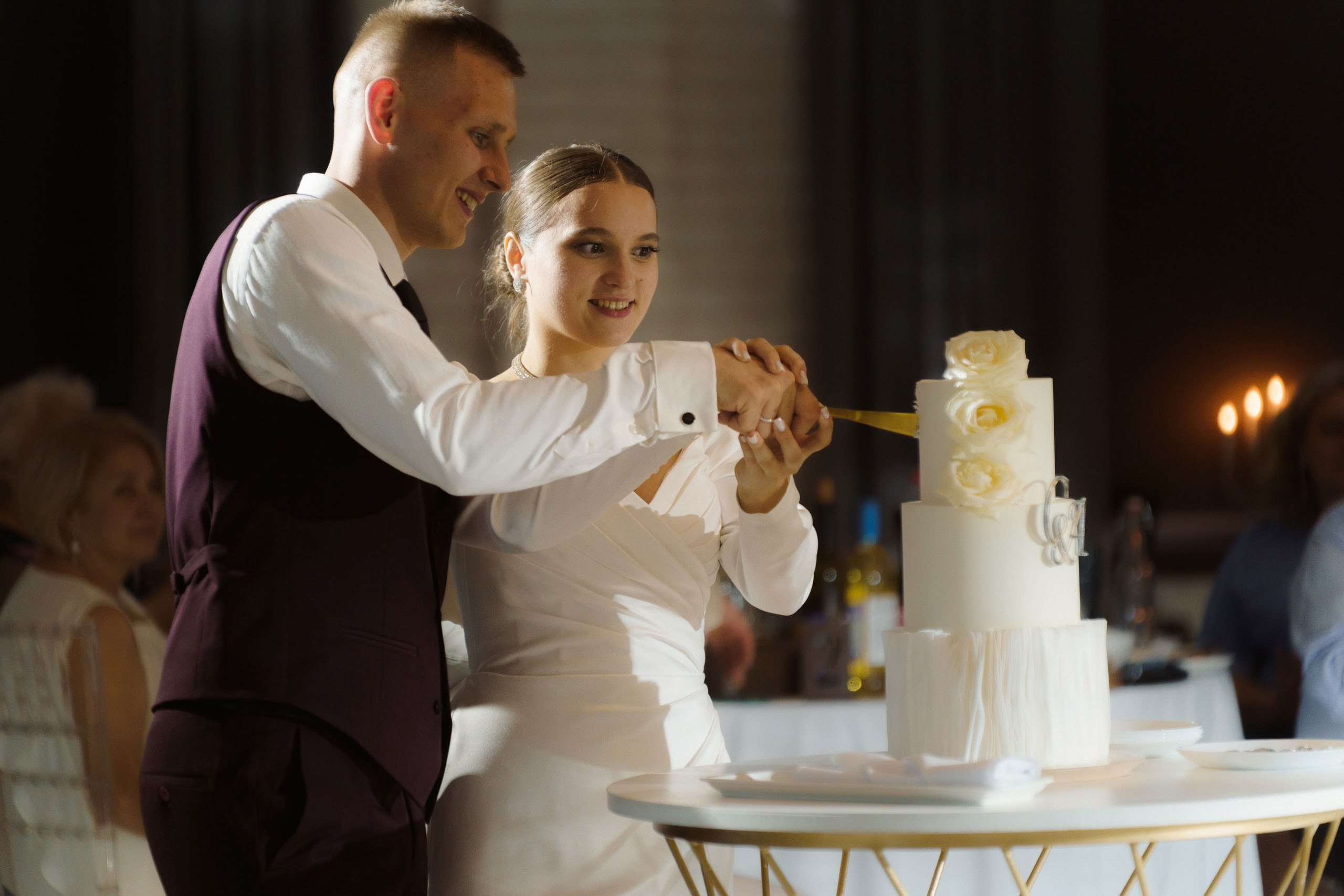 Невеста и жених у стола с тортом во время банкета