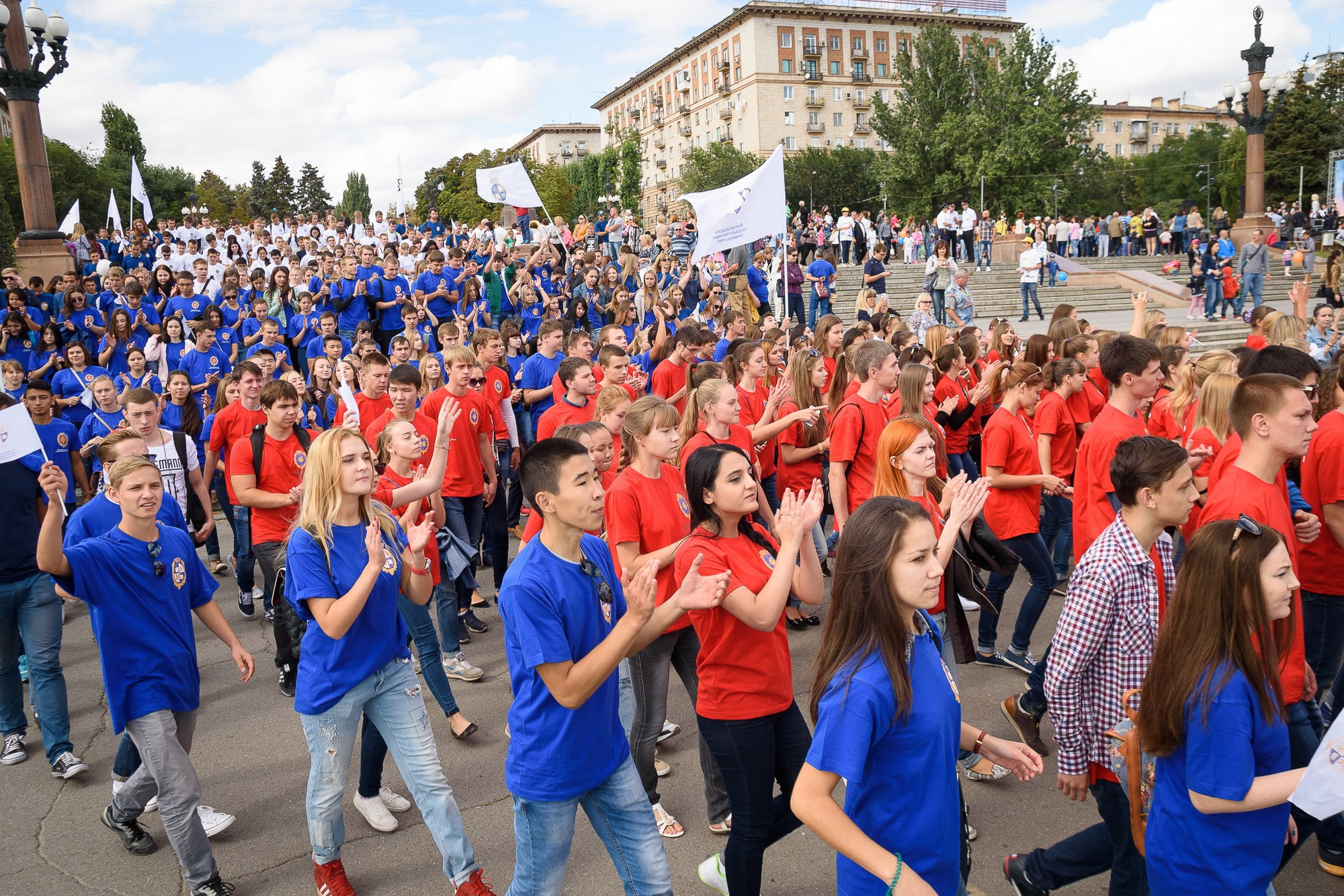 Студенты со знамёнами своих ВУЗов идут на параде