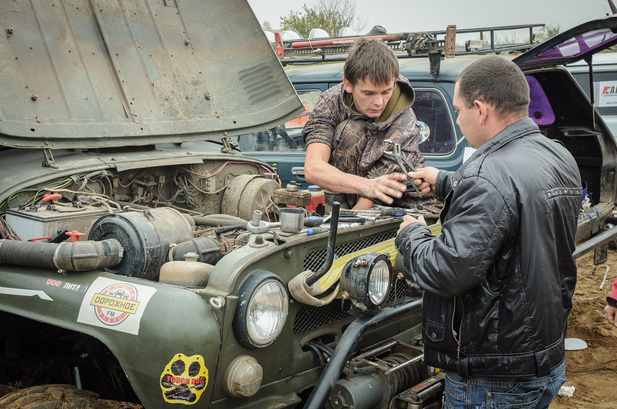 Два мужчины ремонтируют двигатель автомобиля