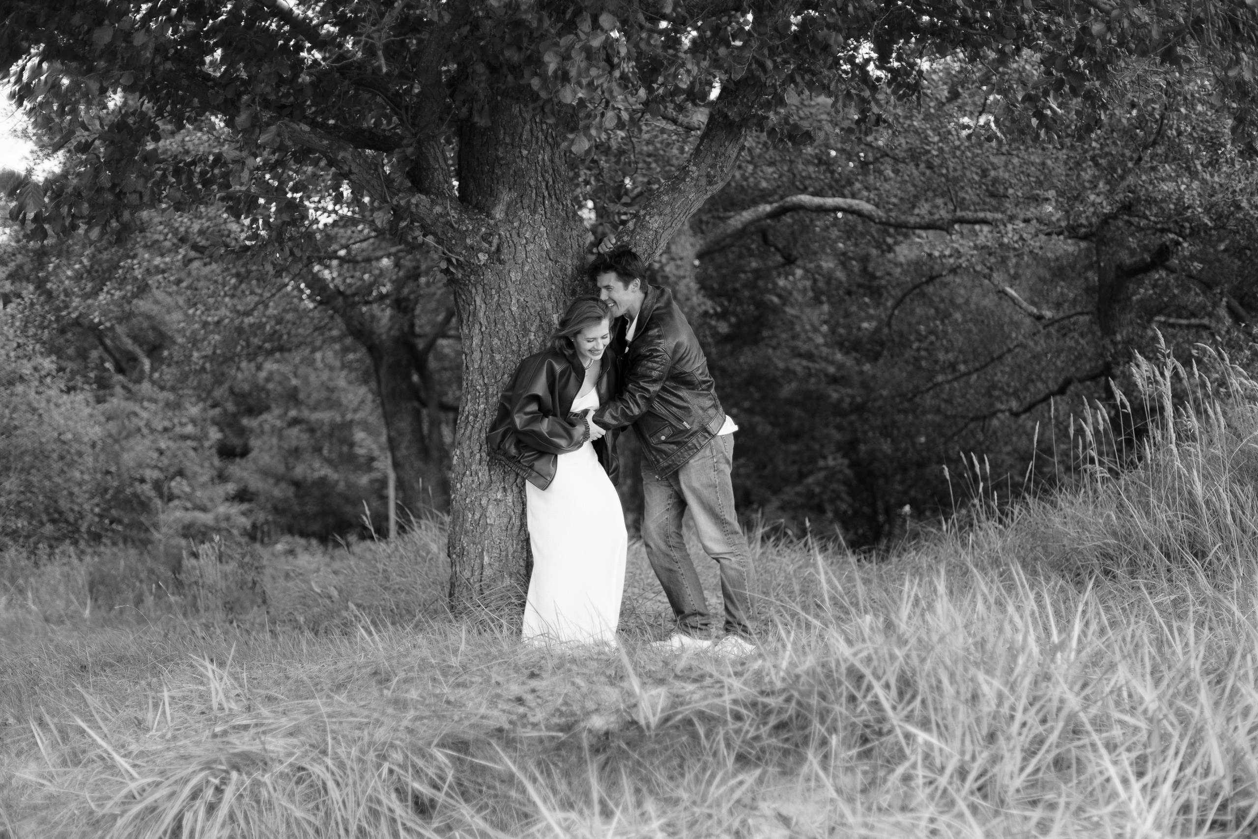 Девушка и парень под деревом — чёрно-белая съёмка в парке у залива