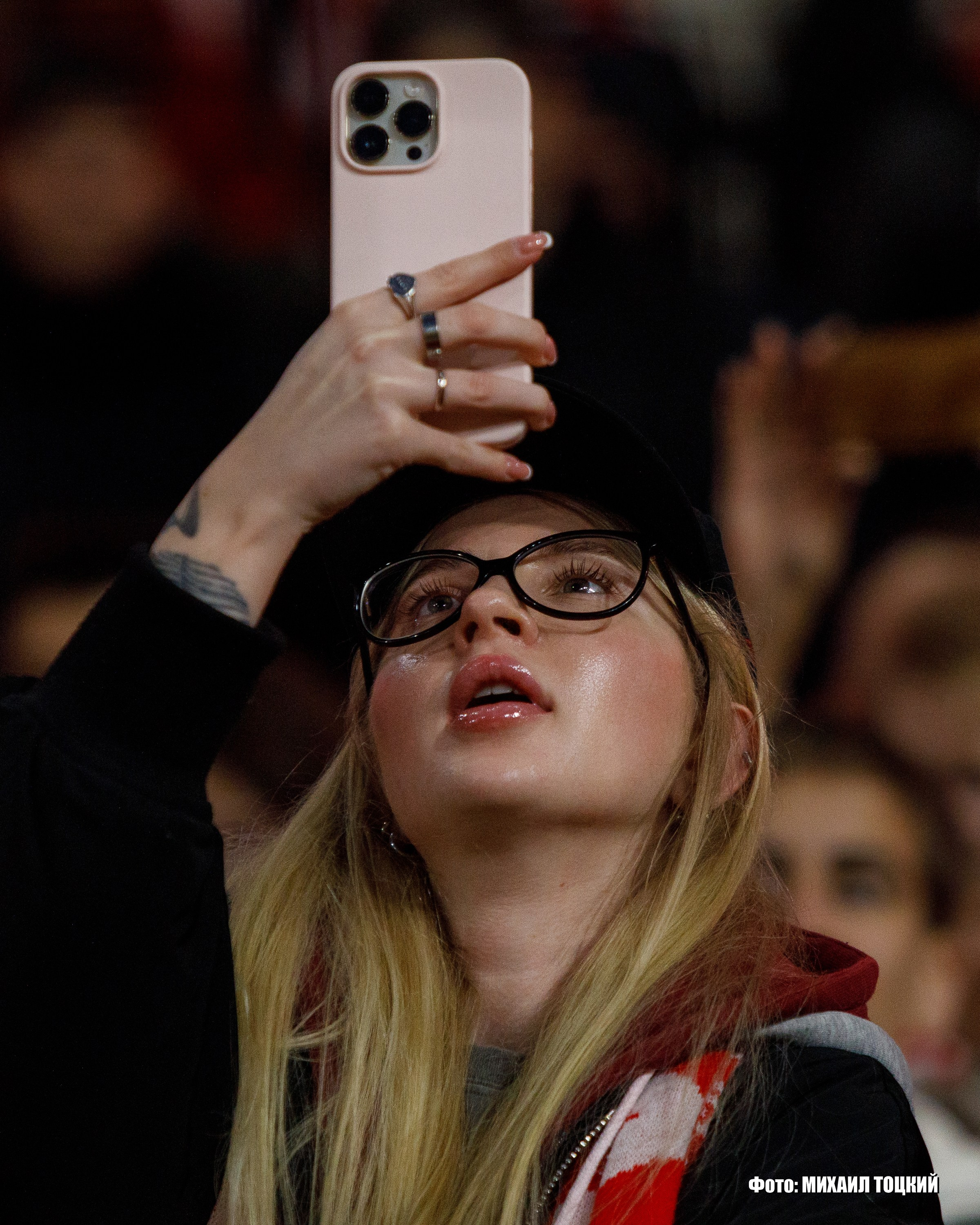 Красивая девушка с мобильным телефоном на трибуне Лукойл Арены