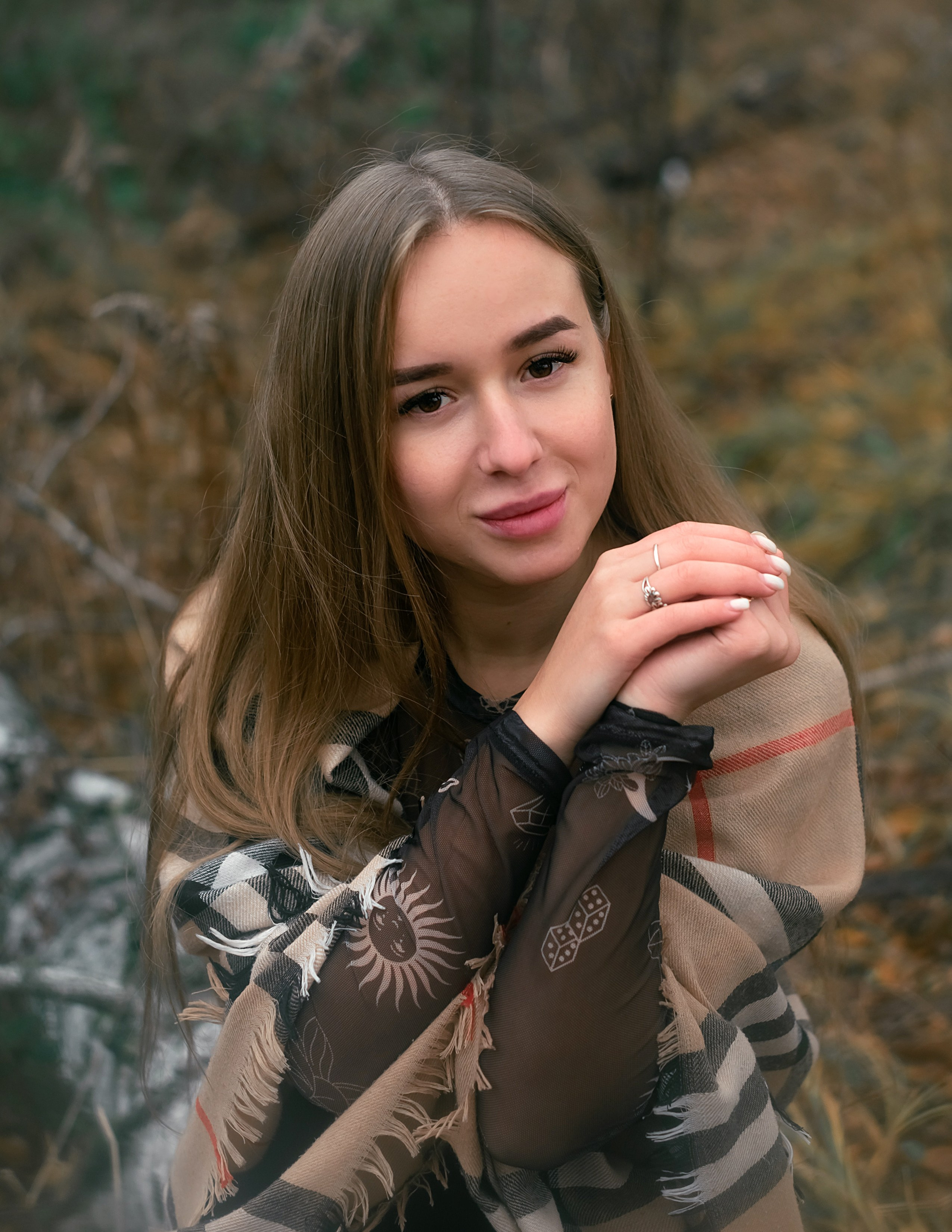 На фото портрет девушки в осеннем лесу.