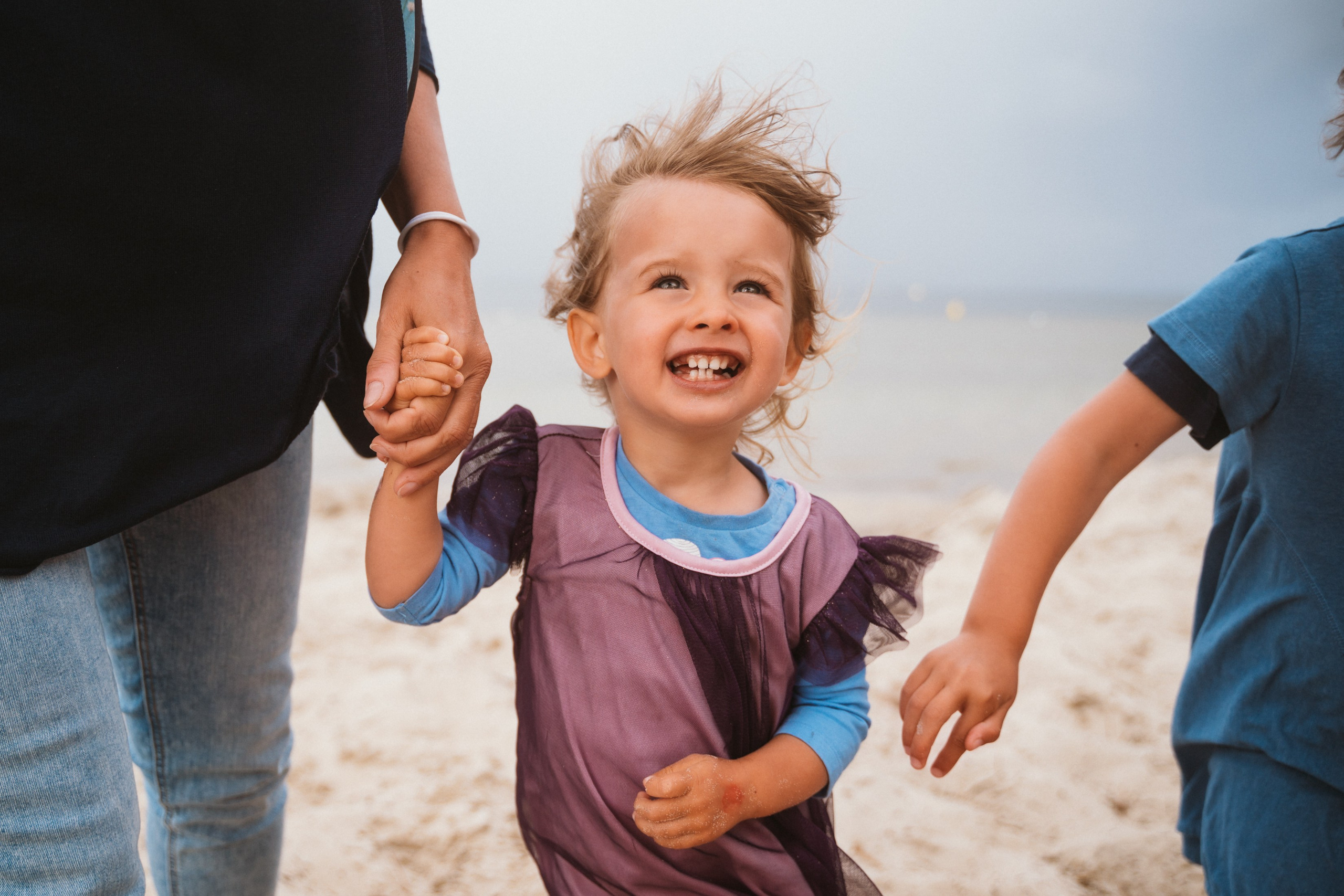 The child's face lit up with joy while playing with their dad in the lake, Tuscany.
