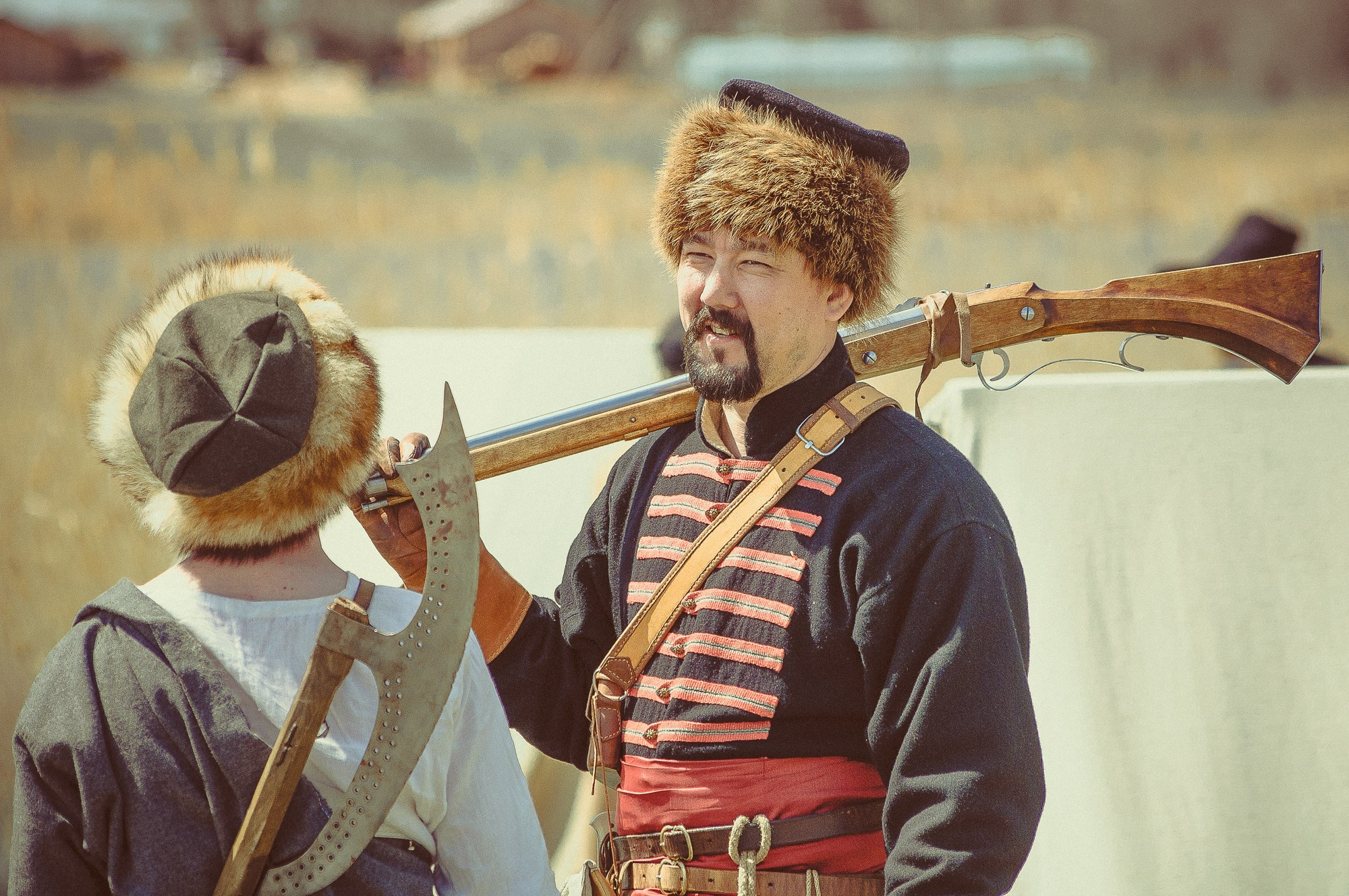 Мужчина в старинной одежде с оружием на плече