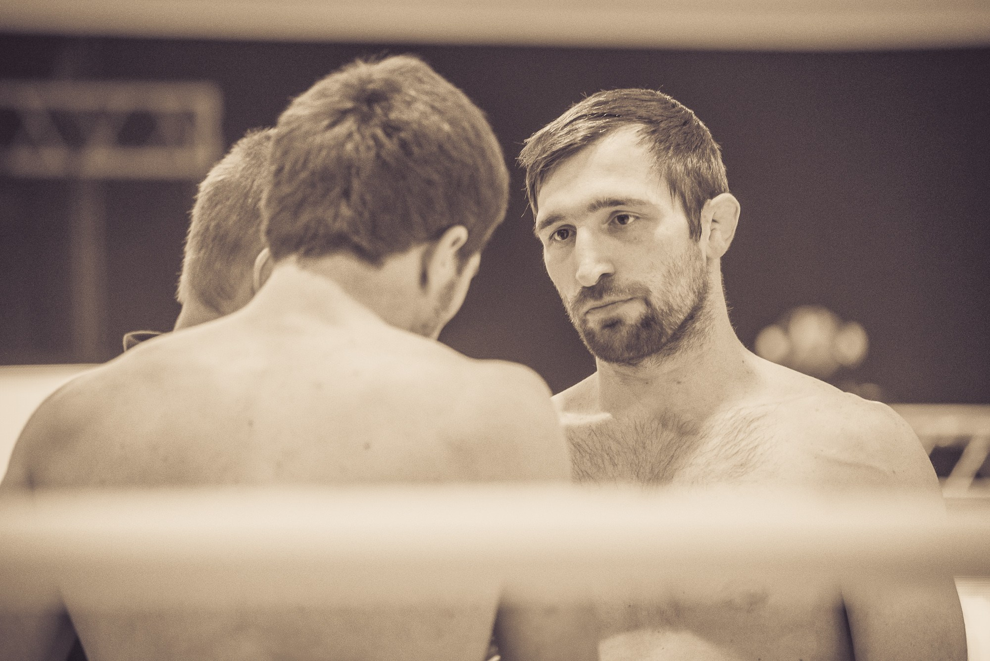 Спортсмен с бородой смотрит на своего соперника перед началом боя