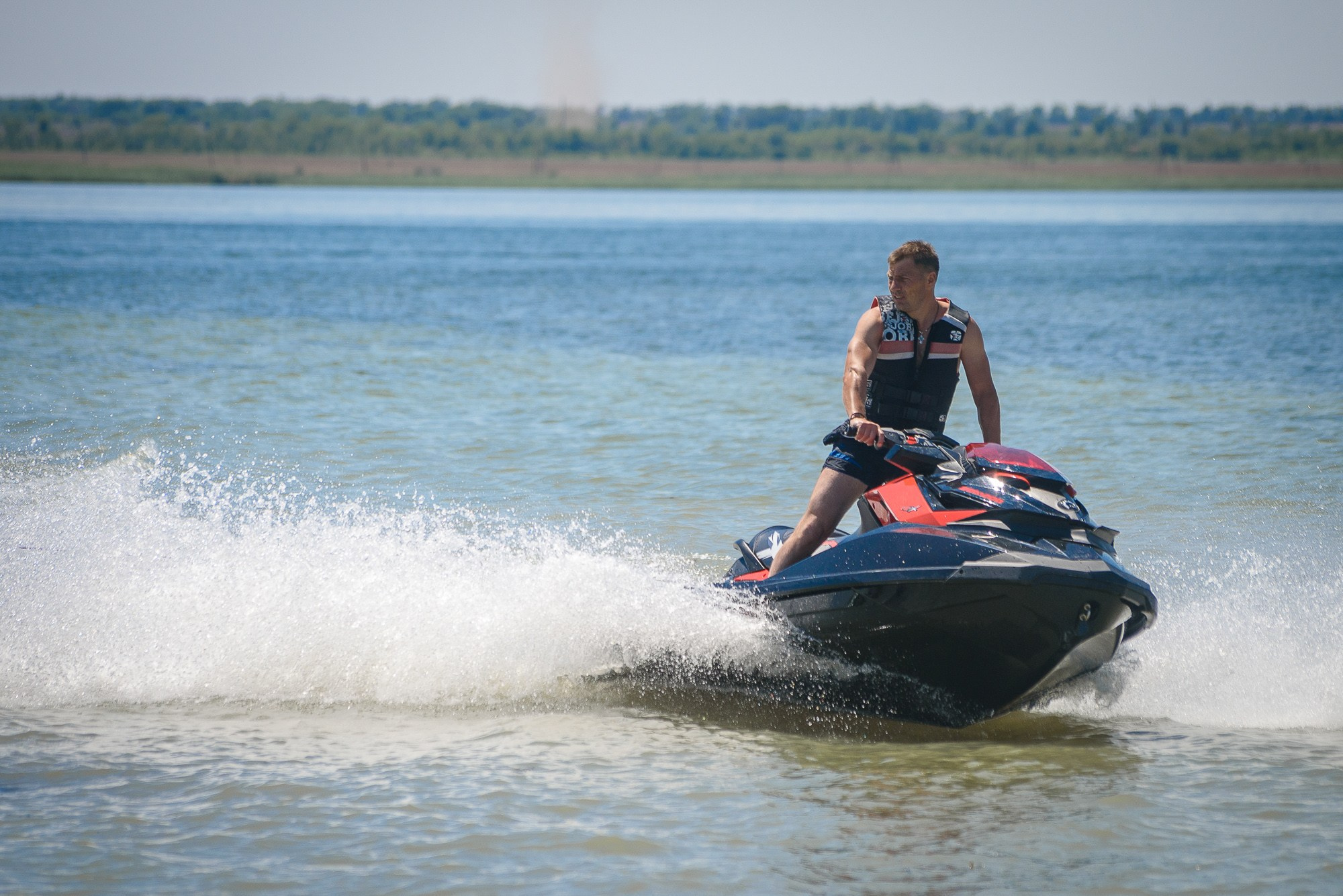 Мужчина на гидроцикле мчится по воде на большой скорости