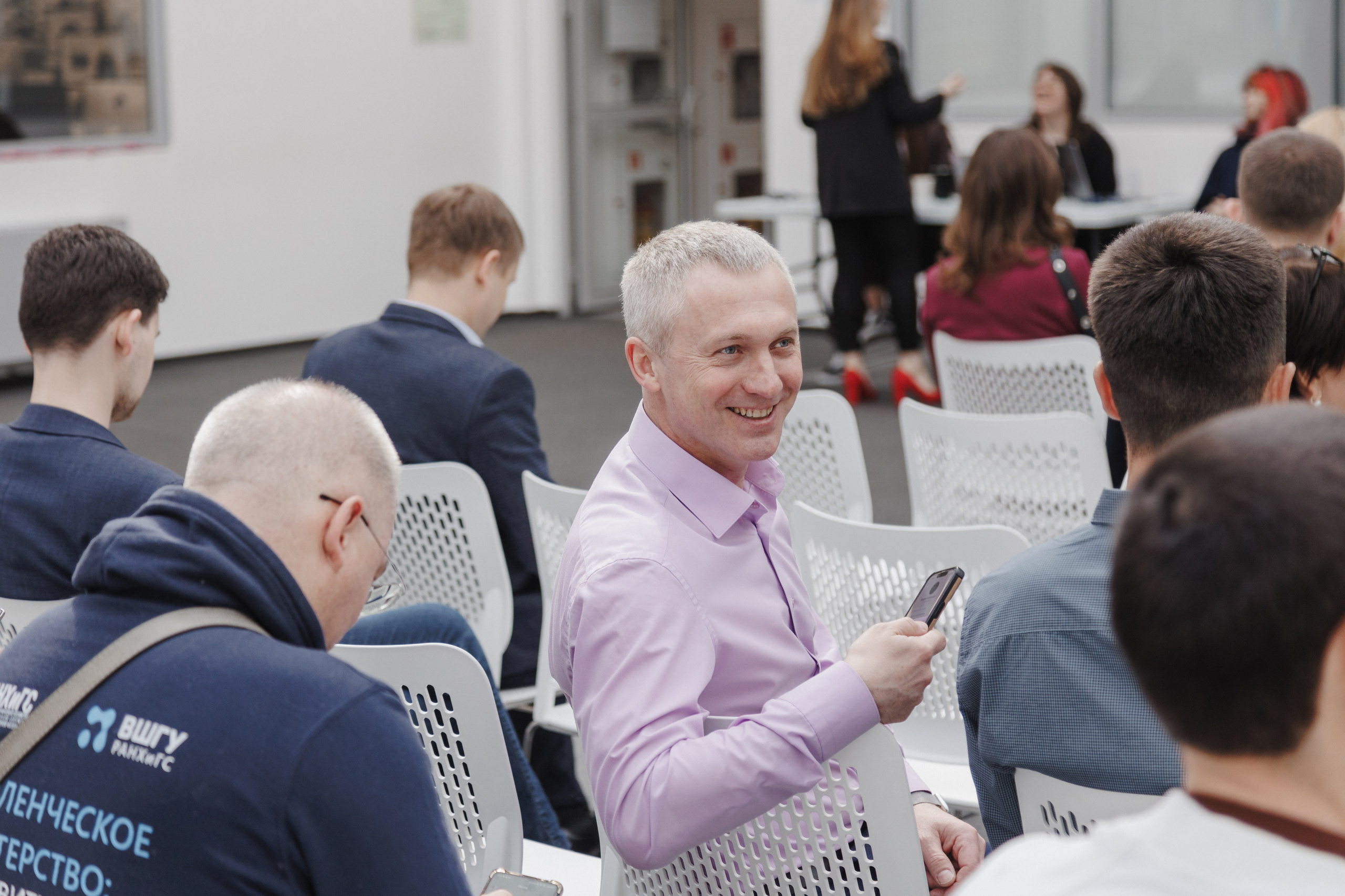 Репортажные портреты: сосредоточенные лица слушателей во время доклада на конференции.