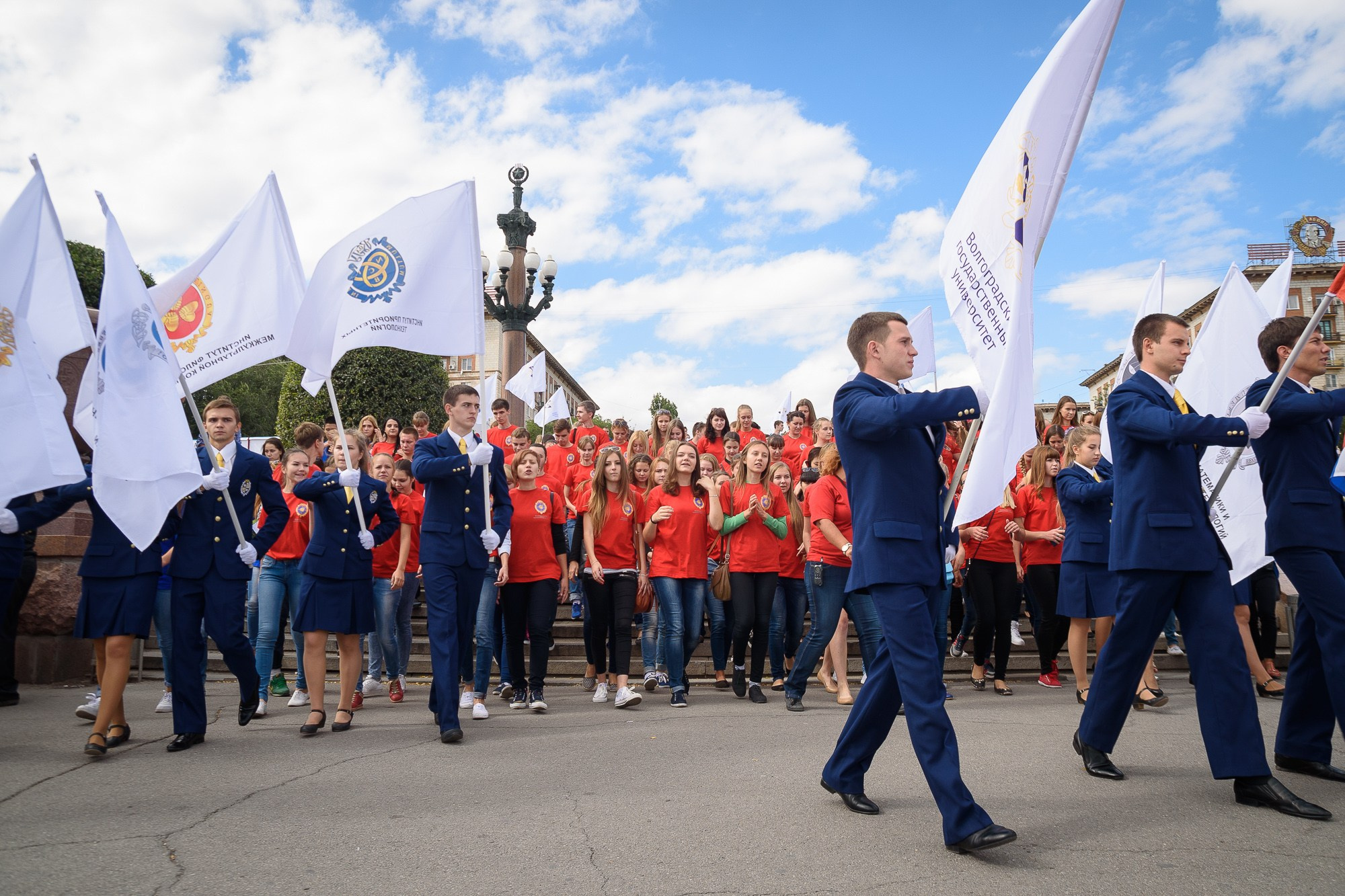 Студенты со знамёнами своих ВУЗов идут на параде