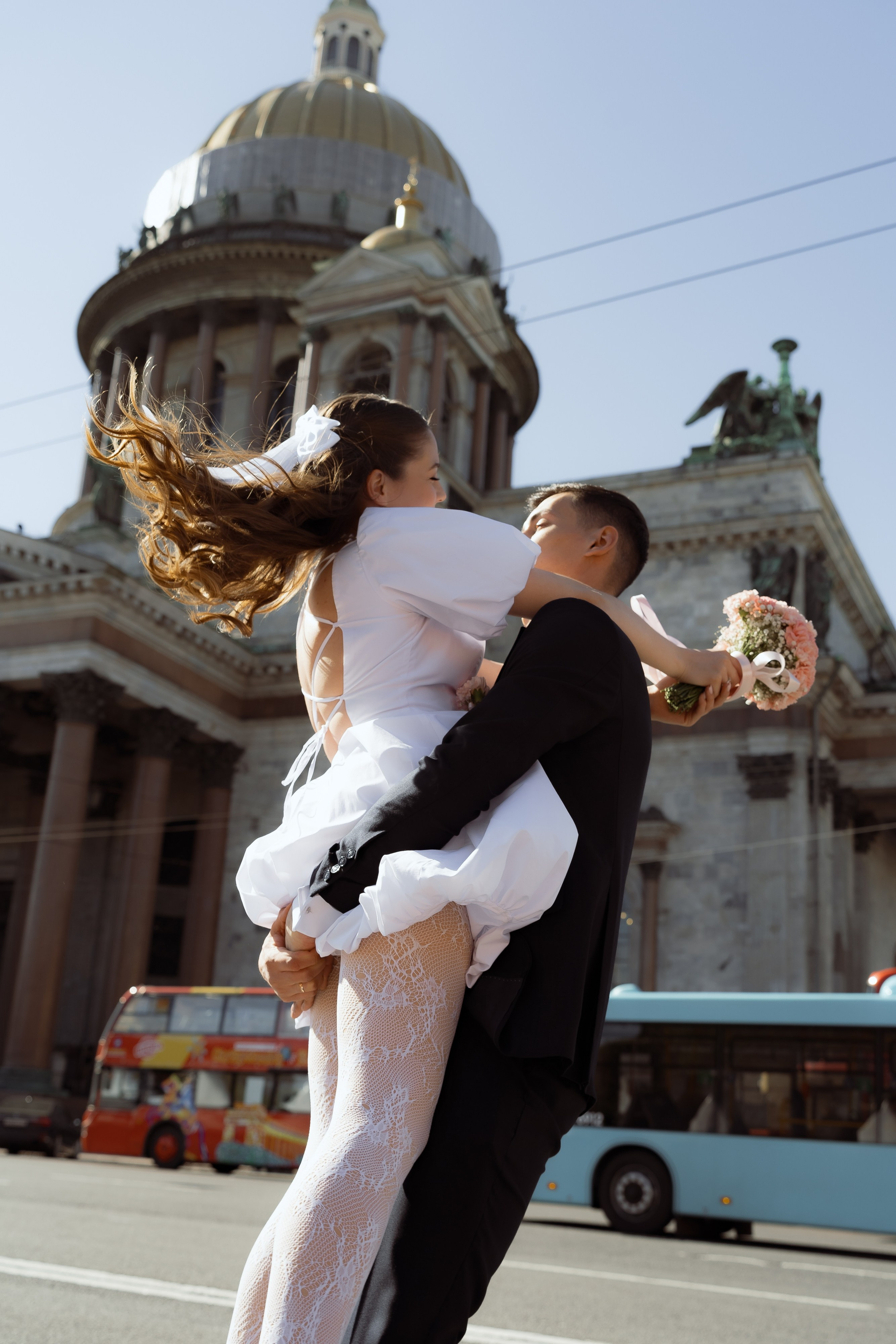 Динамичный кадр с невестой на руках у жениха, свадебная съёмка у Исаакия