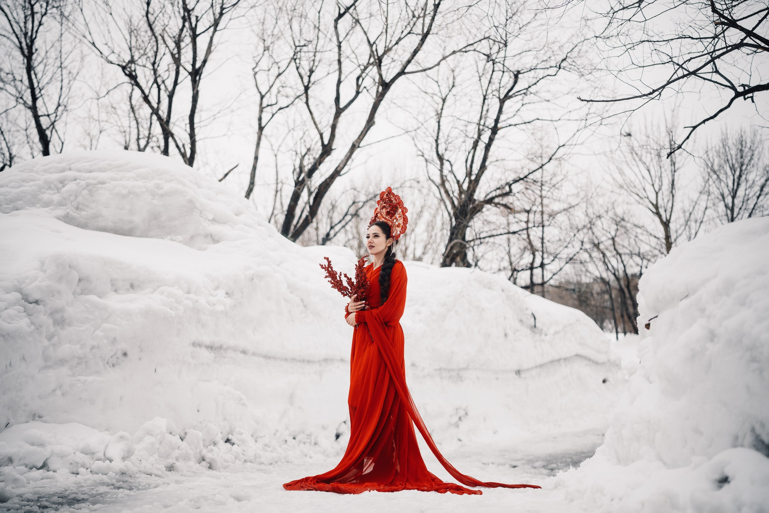 Весенняя фотосессия в городе с моделью в ярком красном образе на фоне грязного снега и улиц, профессиональная съёмка в Камчатке
