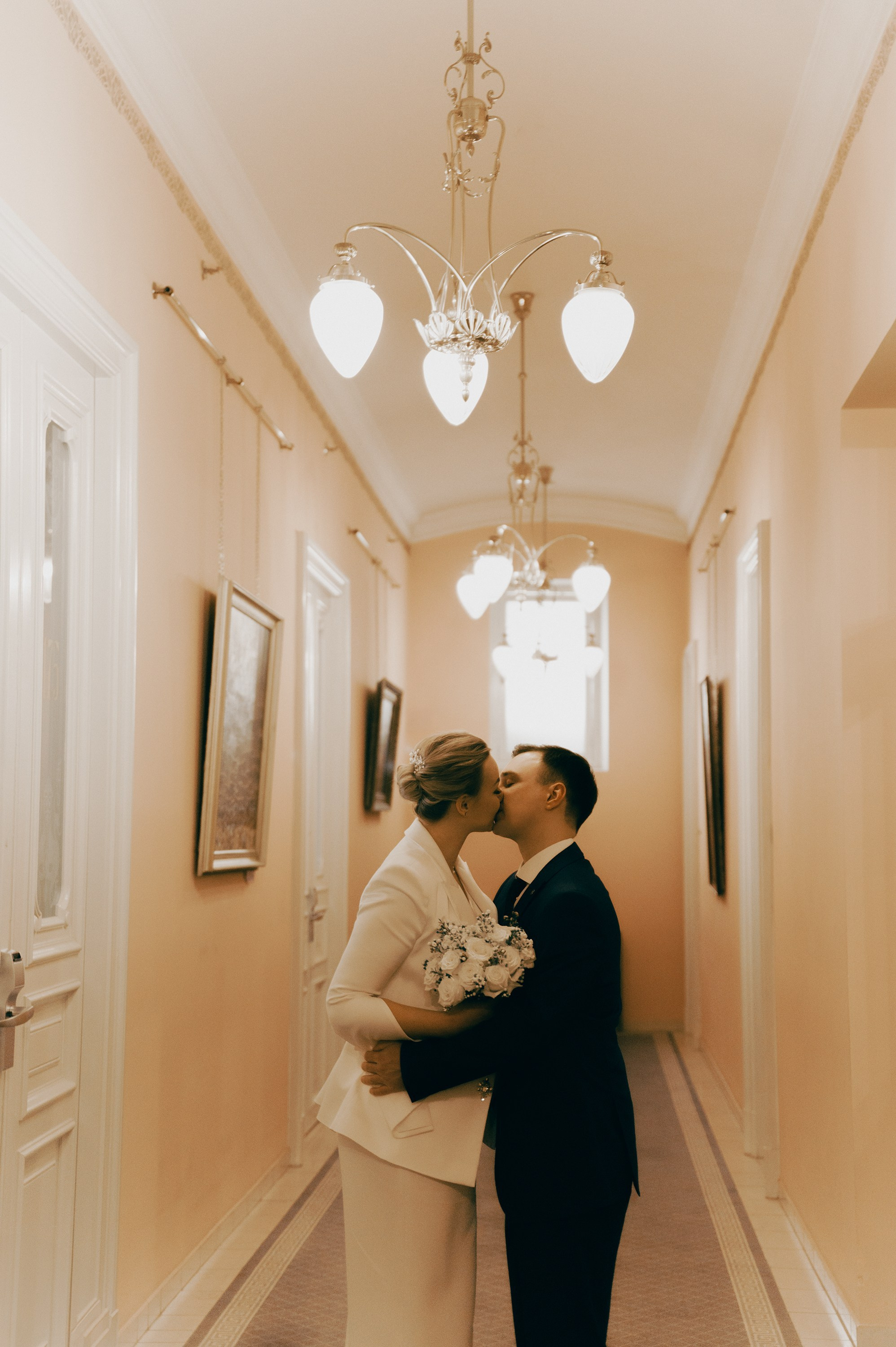 Поцелуй молодожёнов в светлом коридоре — камерная Pinterest wedding съёмка