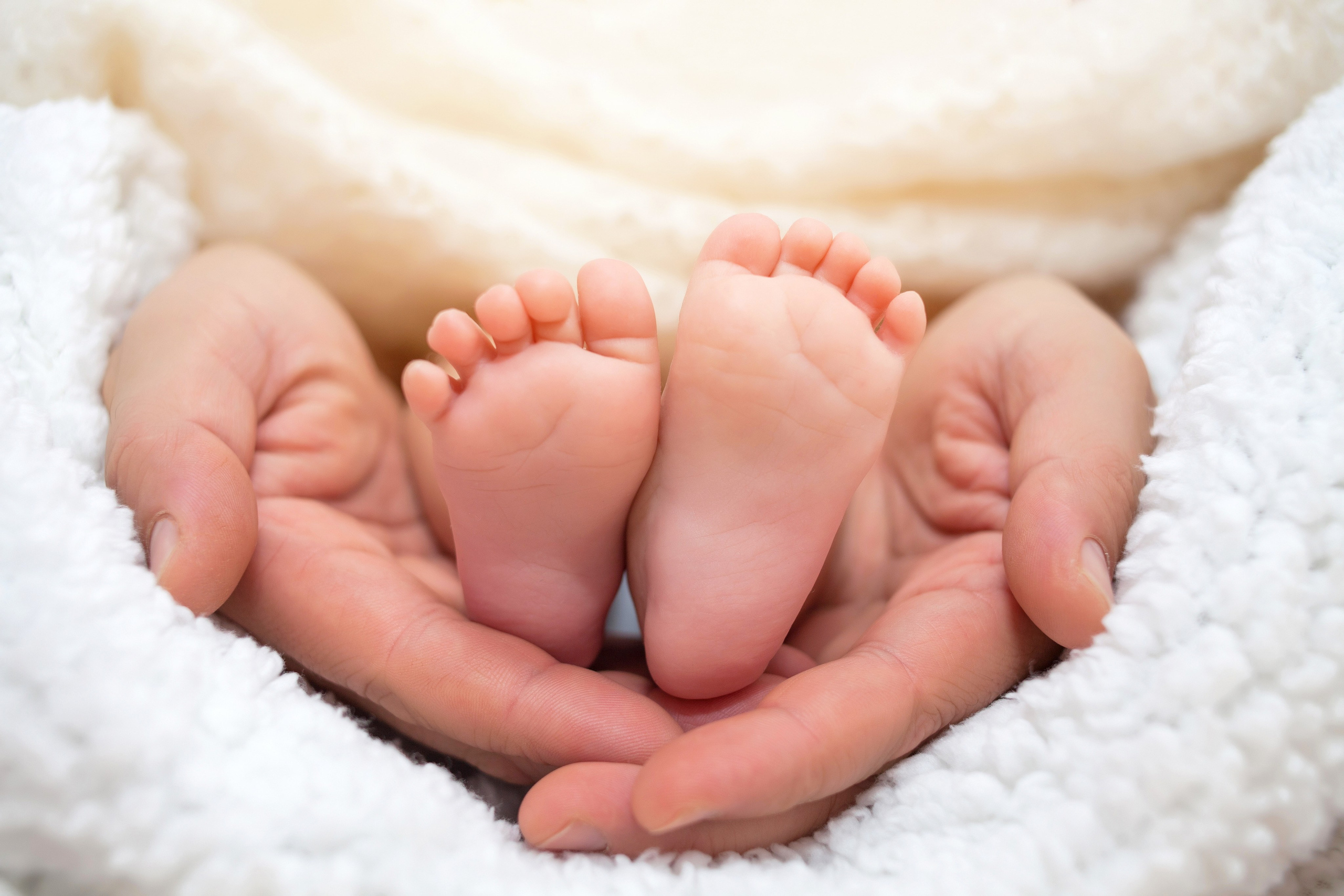 Ножки младенца в ладонях отца