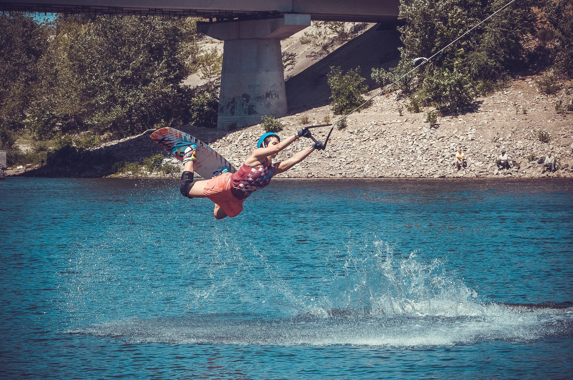 Девушка на вейкборде летит над водой