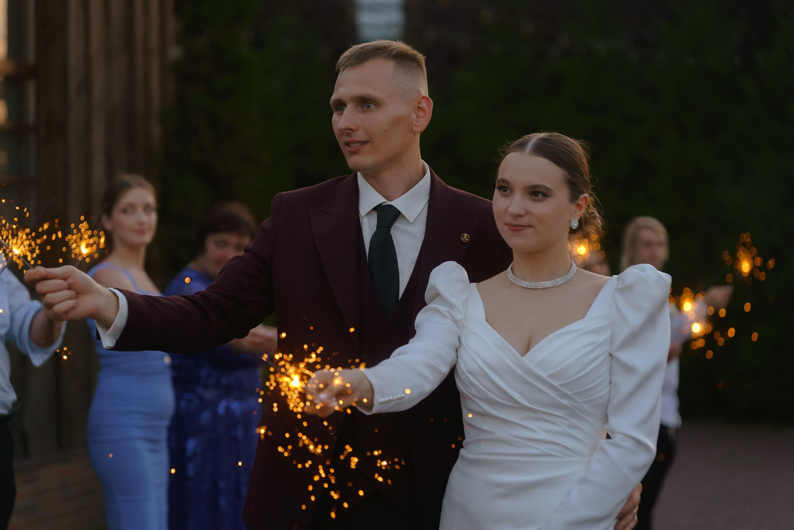 Жених и невеста держат бенгальские огни на вечерней прогулке