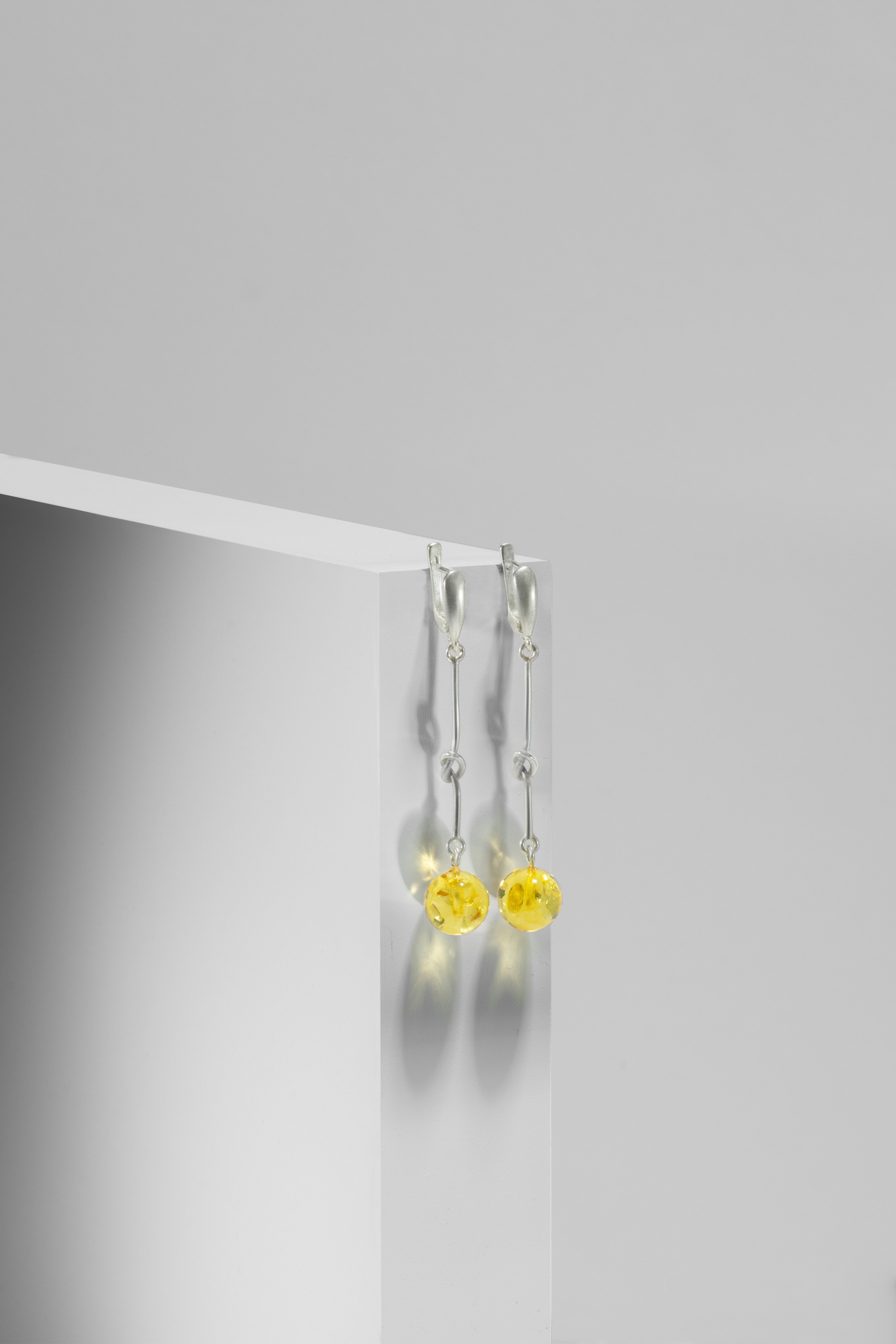 янтарные серьги на подиуме предметная фотография