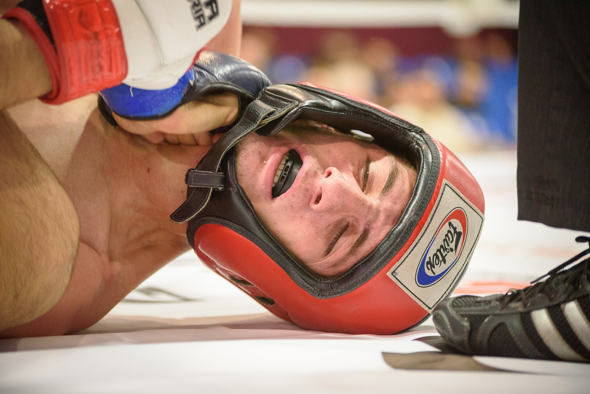 Судья меряет пульс потерявшему сознание бойцу ММА