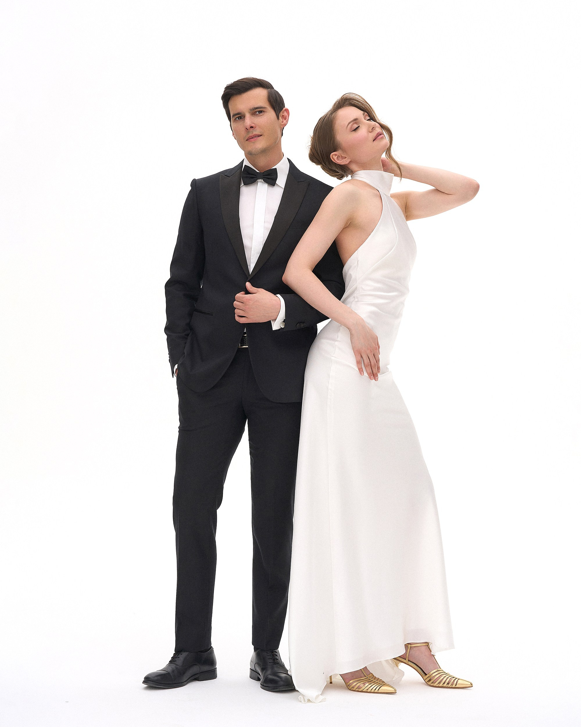 Пара стоит в полный рост на белой циклораме. Никаких лишних движений, только чистая нежность и спокойствие. Свадебный портрет, фотограф Дмитрий Цветков, СПб