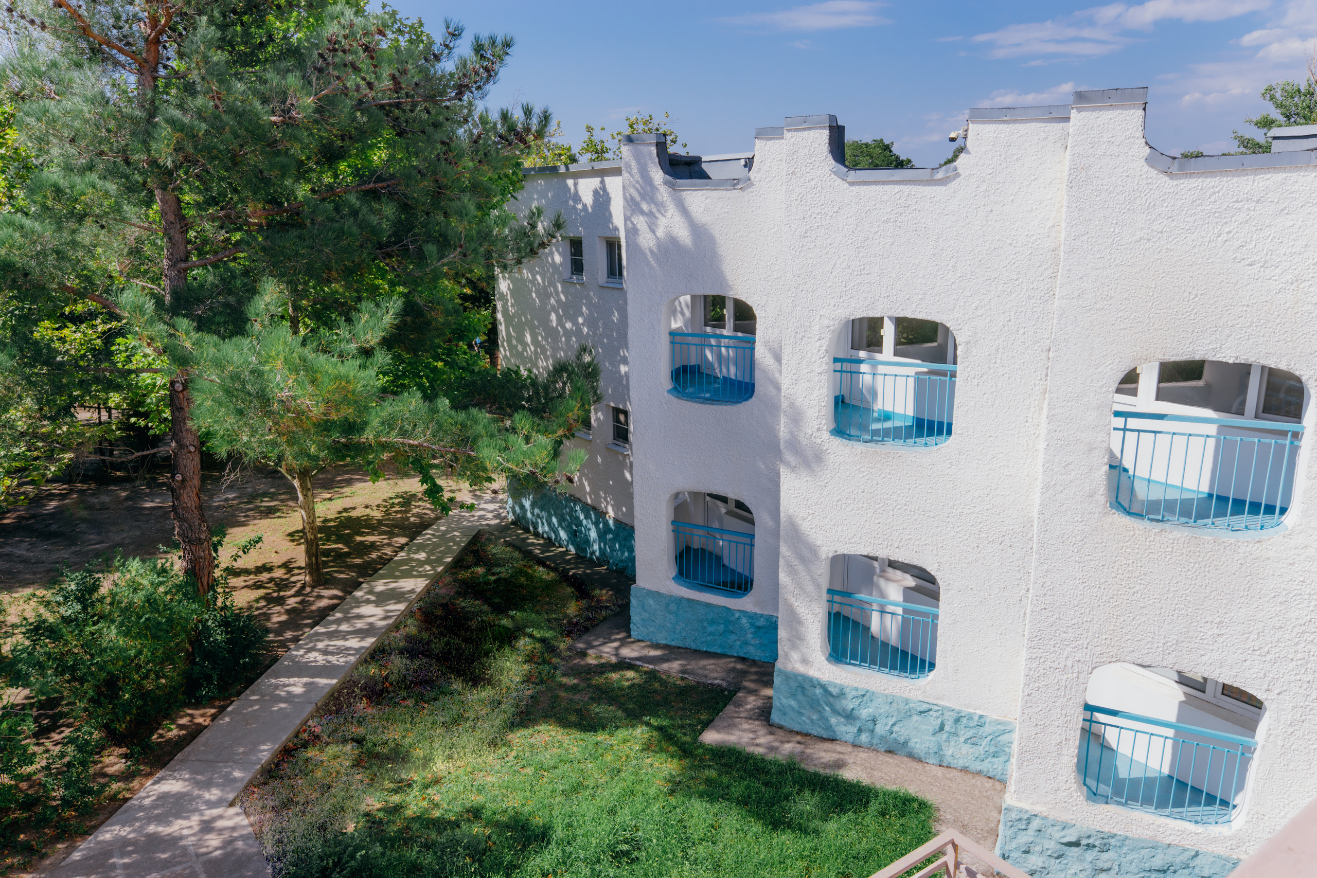 Жилые корпуса детского лагеря, рядом - хвойные деревья