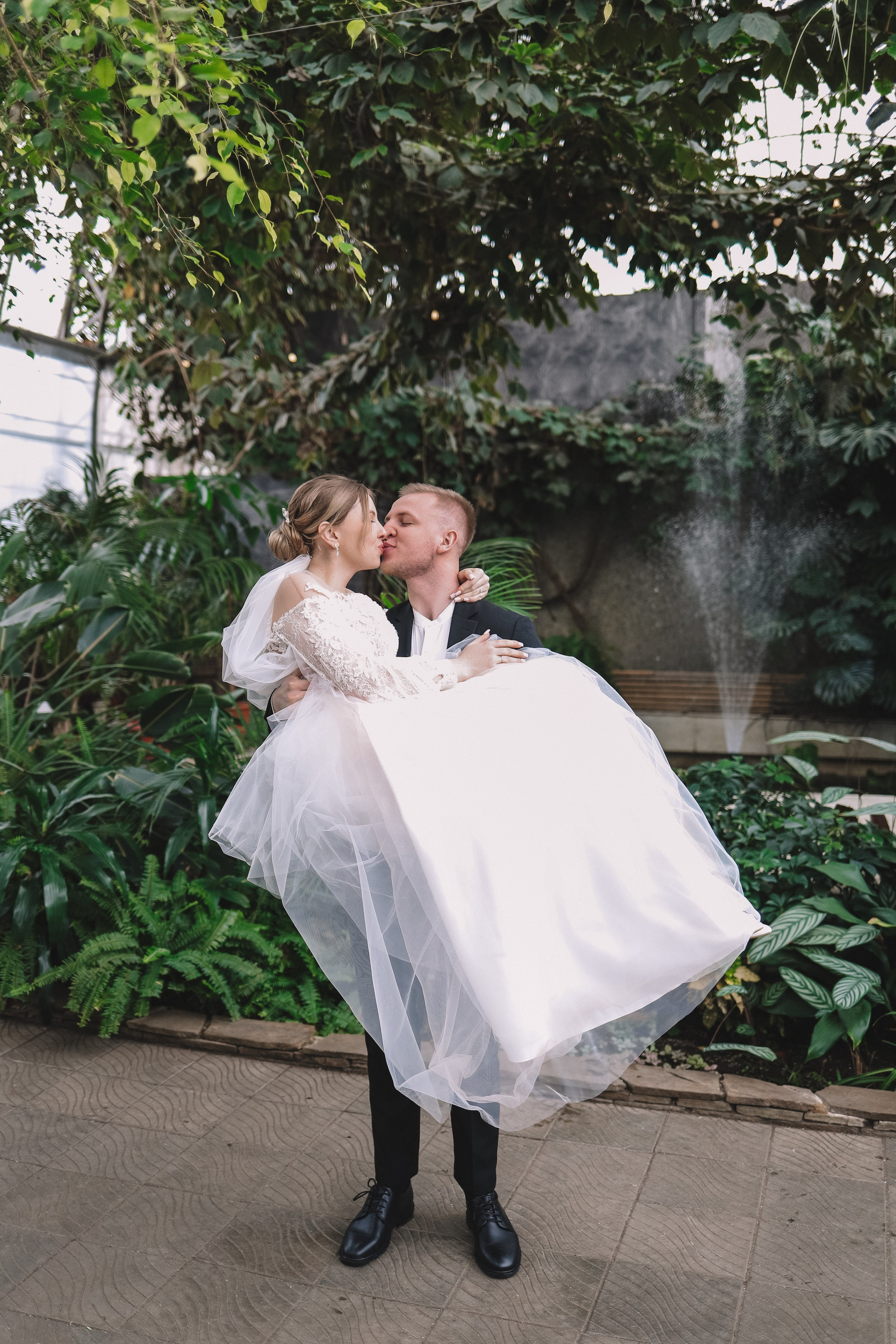 Жених держит невесту на руках, радостный момент