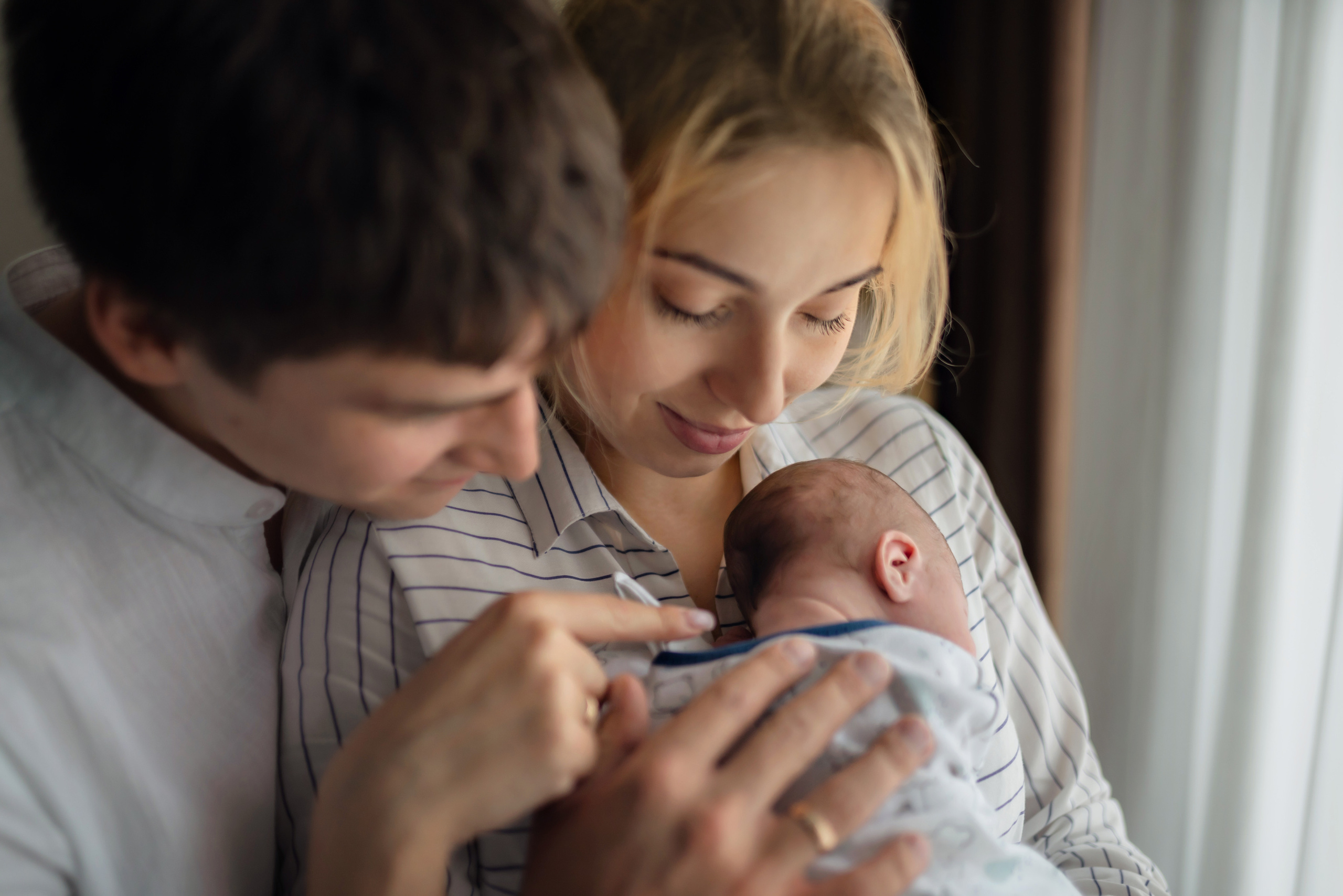Intimate black-and-white labor and delivery photo of a mother and partner