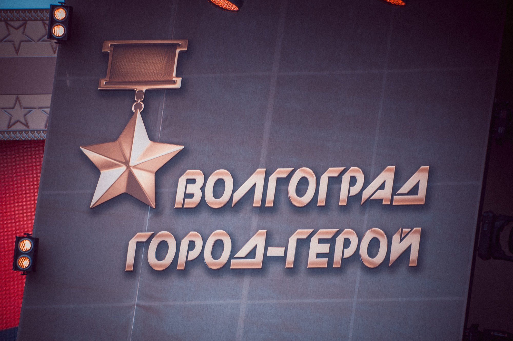 Надпись " Волгоград город-герой" на сцене и изображение медали