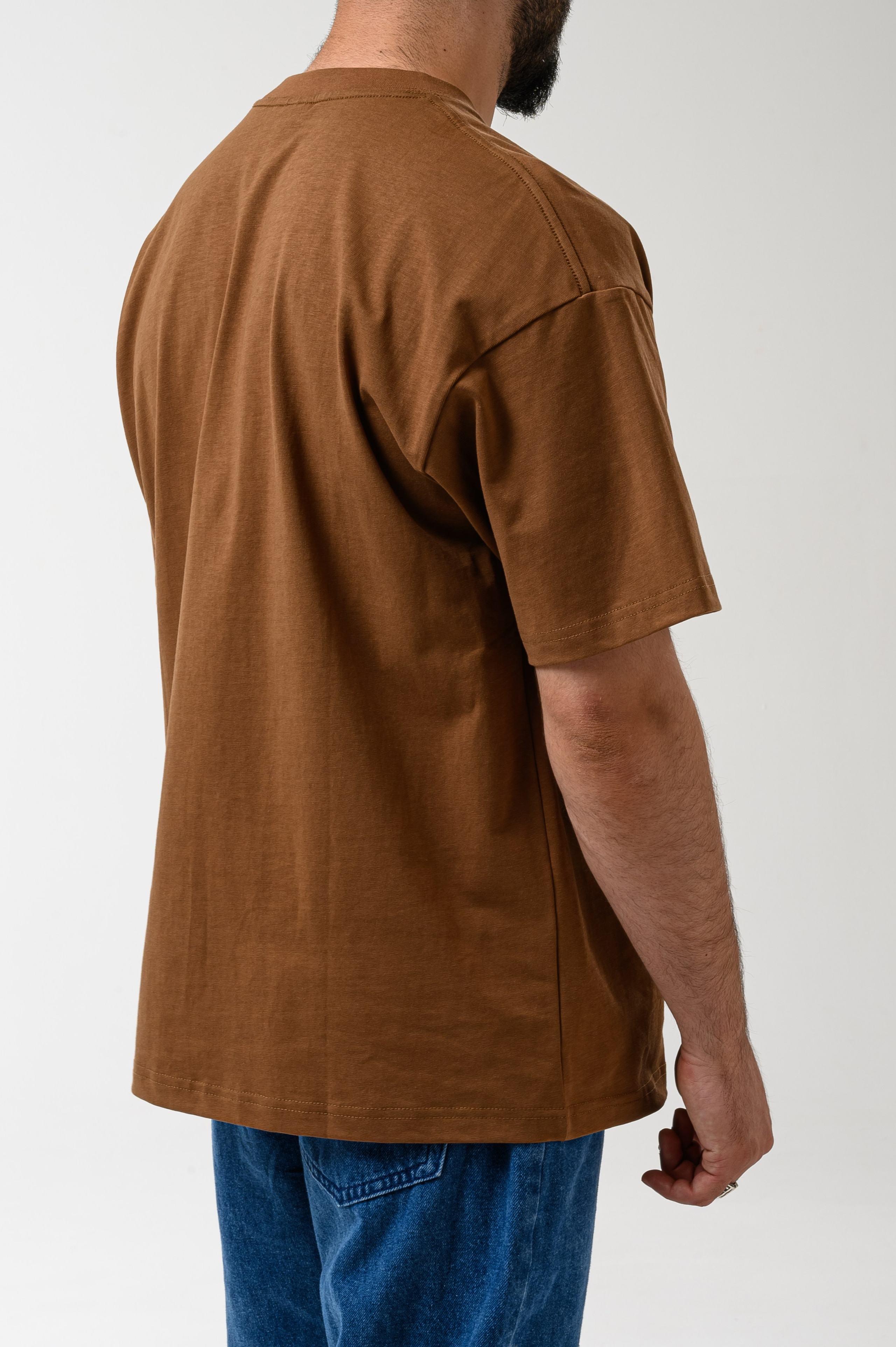 Вид спины мужской футболки, студийная съёмка на белом фоне от фотографа Алексея Клейменова