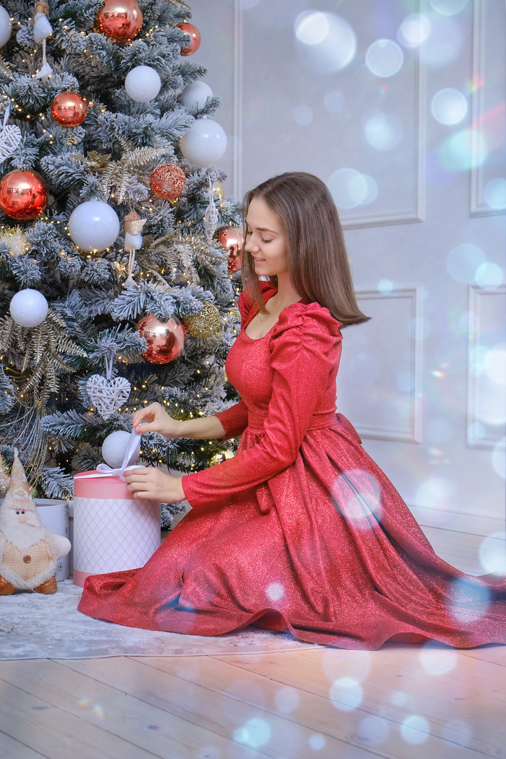 Новогодняя фотосессия для девушки - девушка у ёлки разбирает подарки