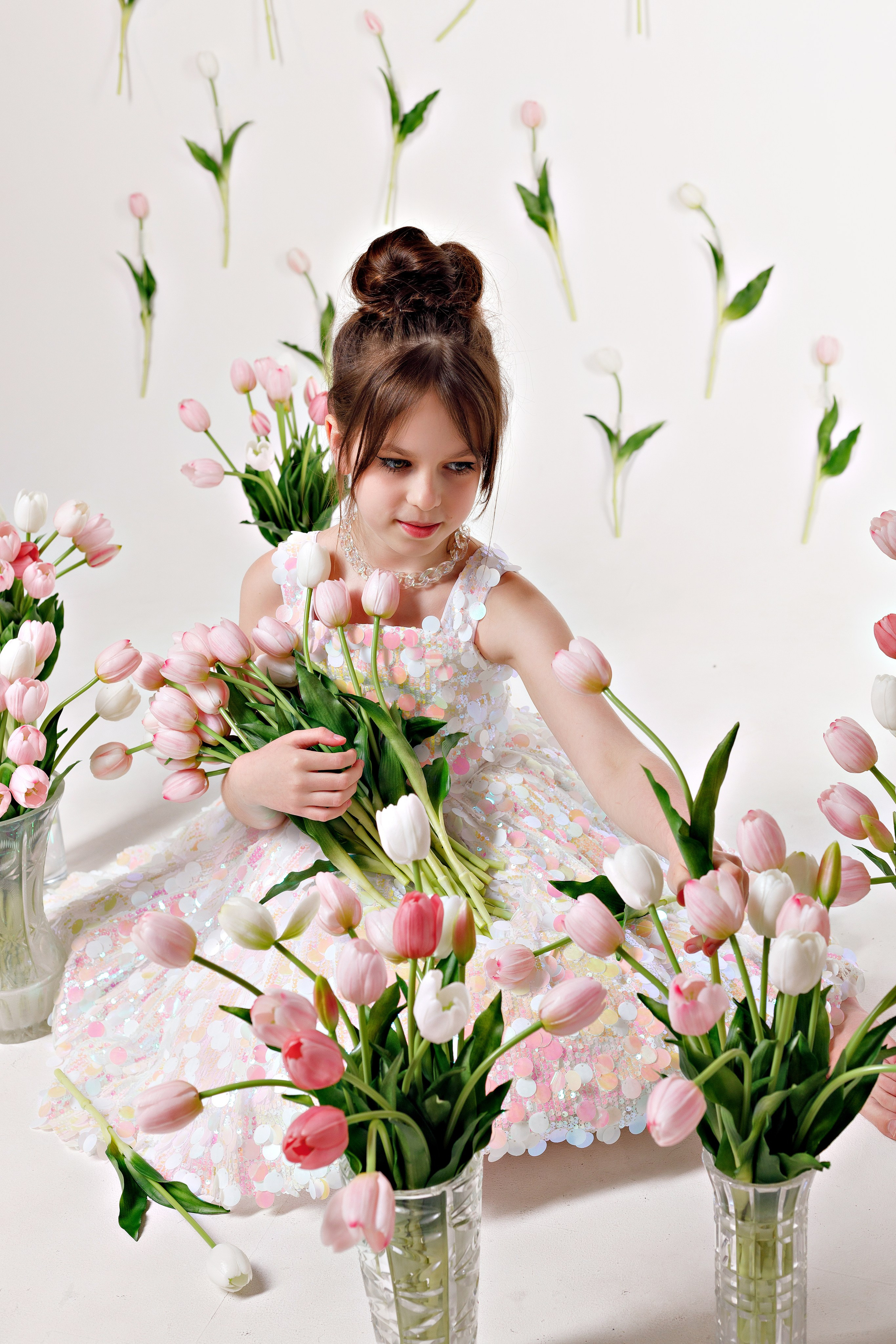 Девочка позирует с цветами на фоне воздушных шаров и праздничной атрибутики в Сочи