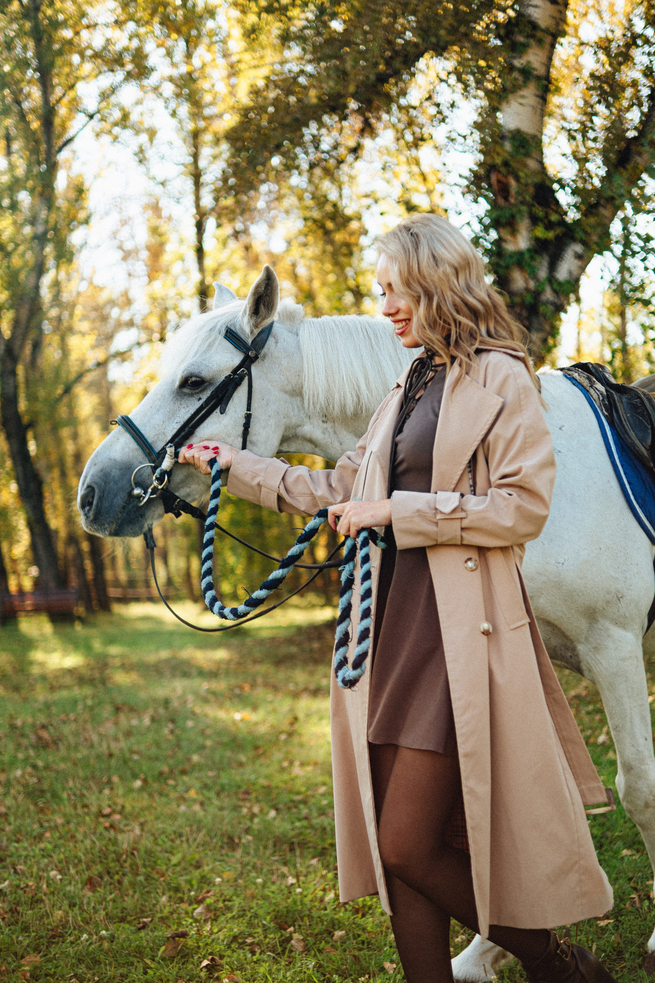 Девушка блондинка с белой лошадью в осеннем лесу
