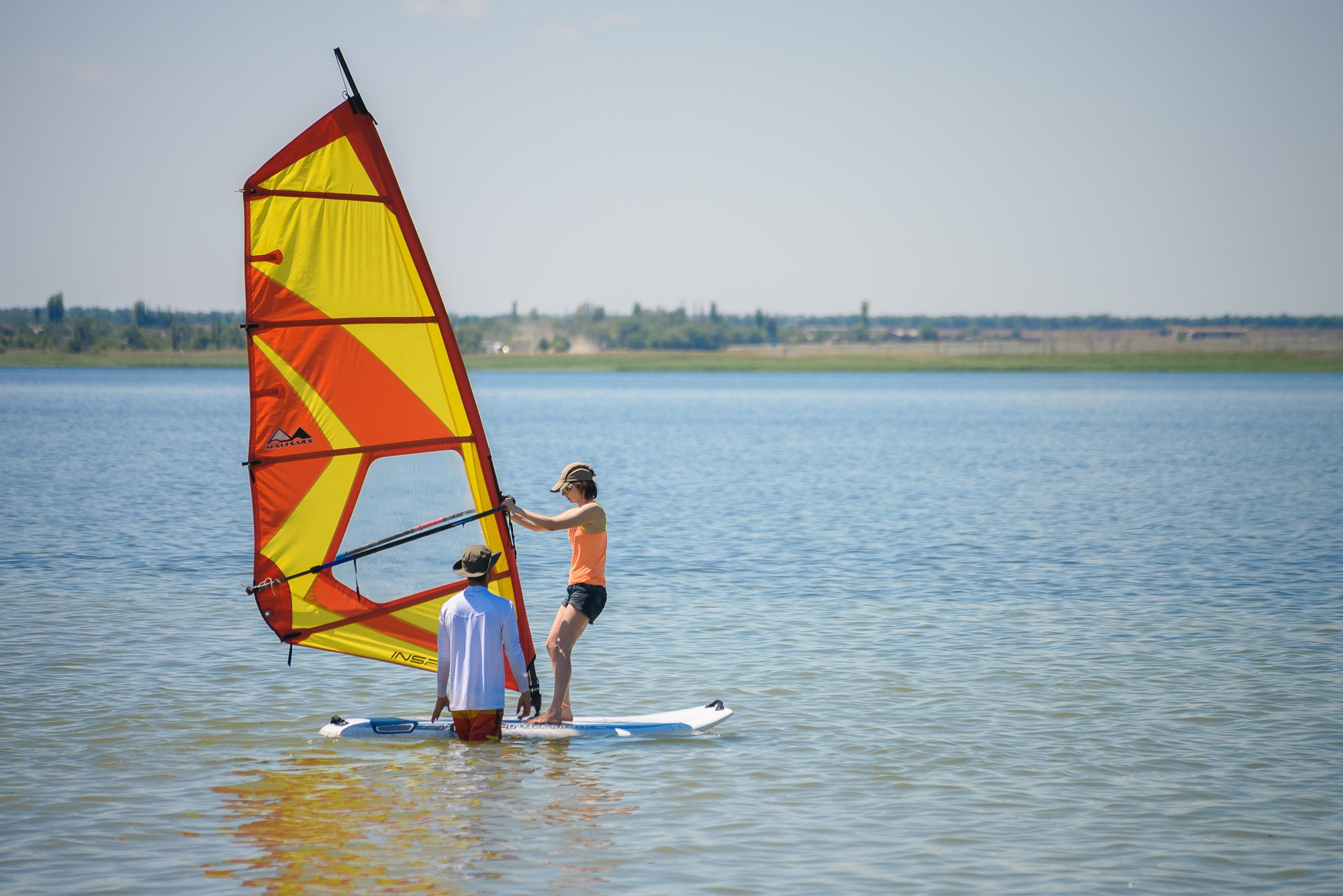Желто-оранжевый виндсёрф в воде