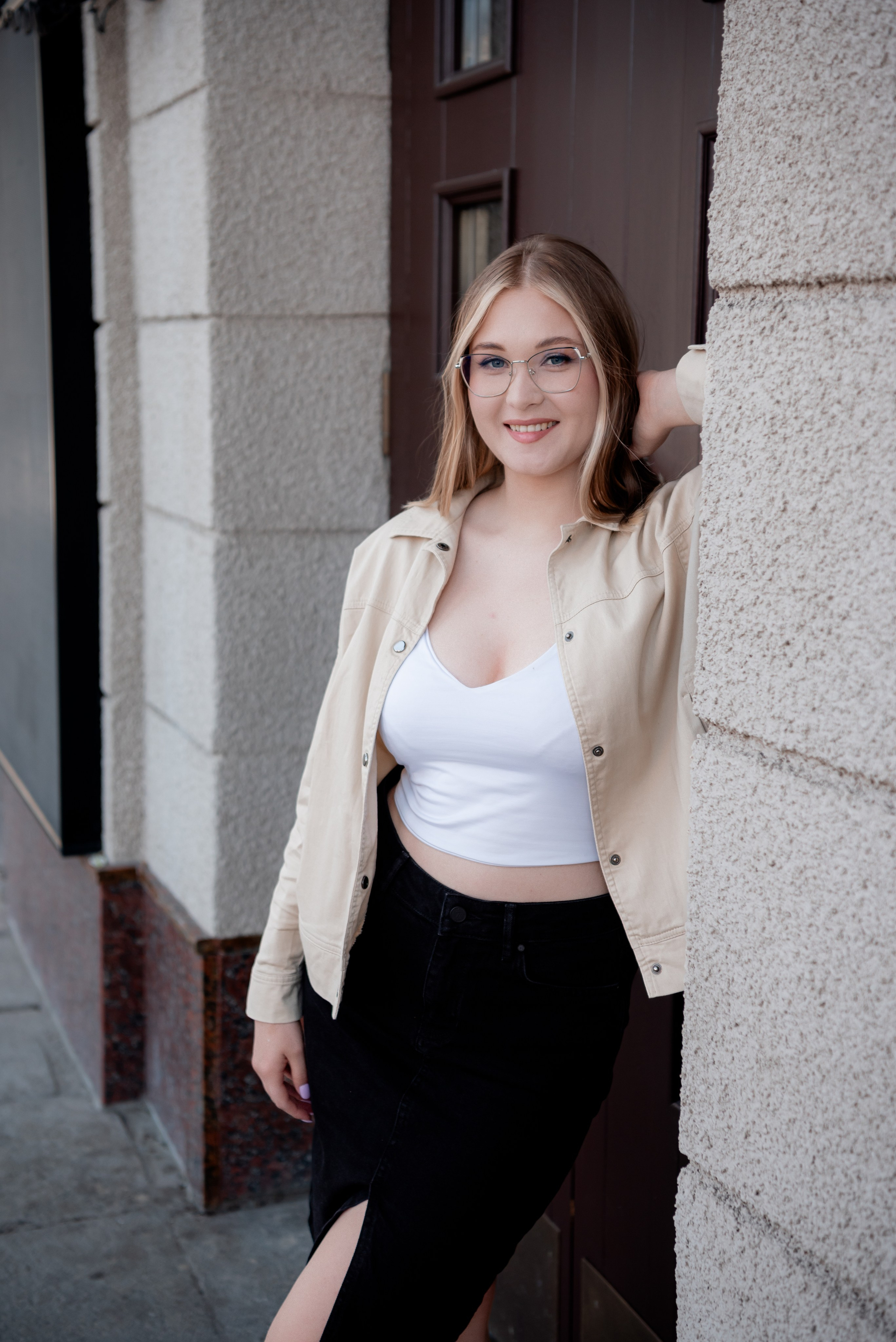 Красивая девушка в белом топике, чёрной юбке возле входной двери НЭТ в Волгограде