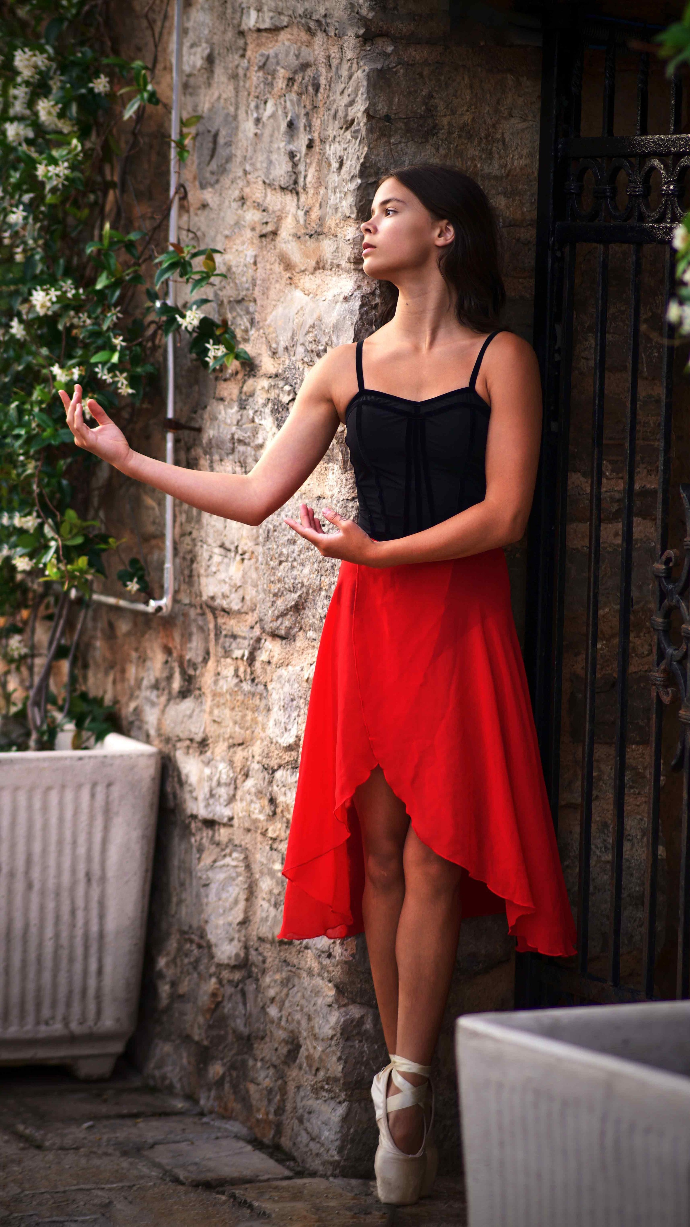Young ballerina posing in Budva Old Town at sunrise