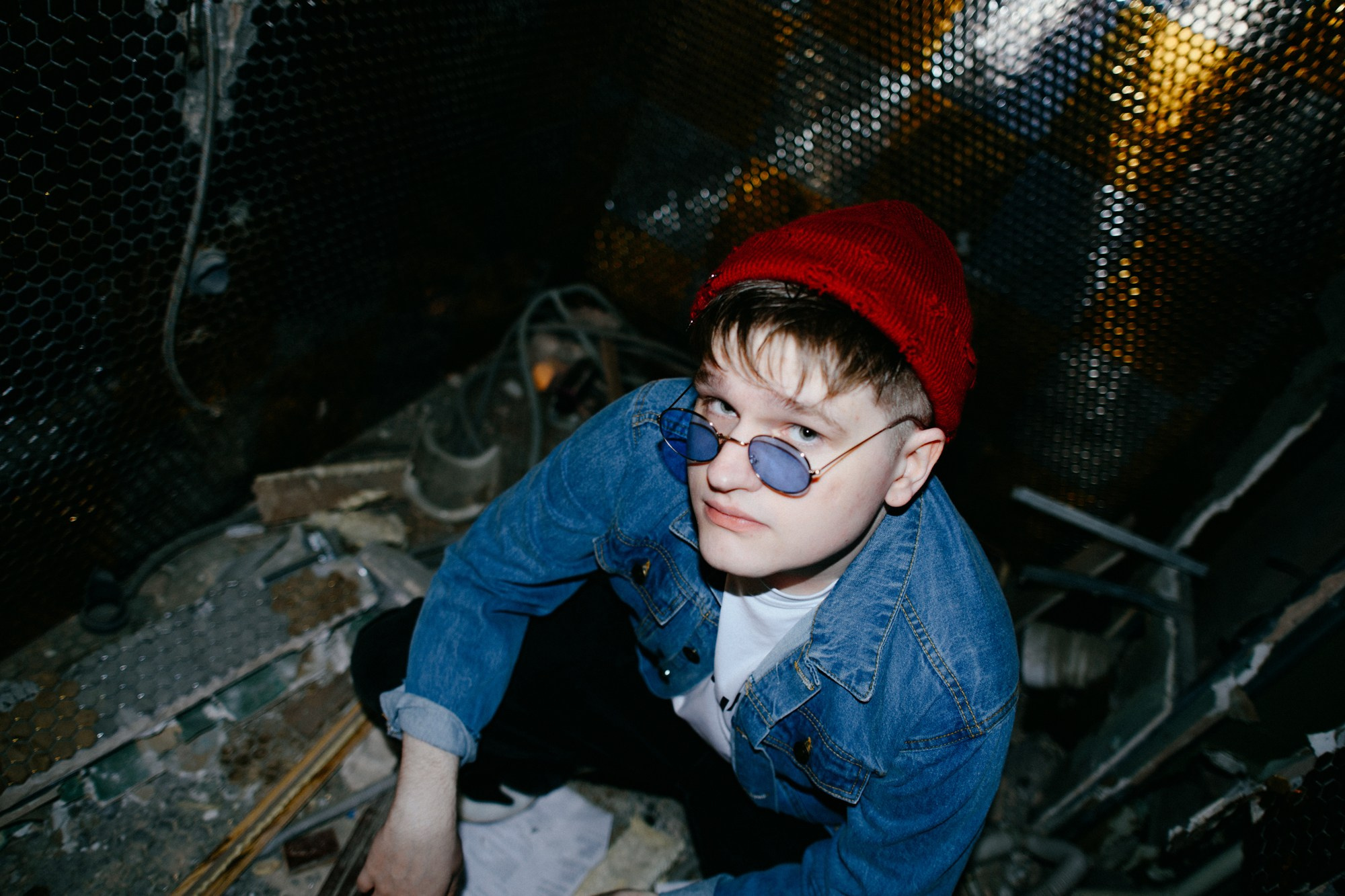 Крупный план, мужской портрет в очках, холодный свет заброшенного здания